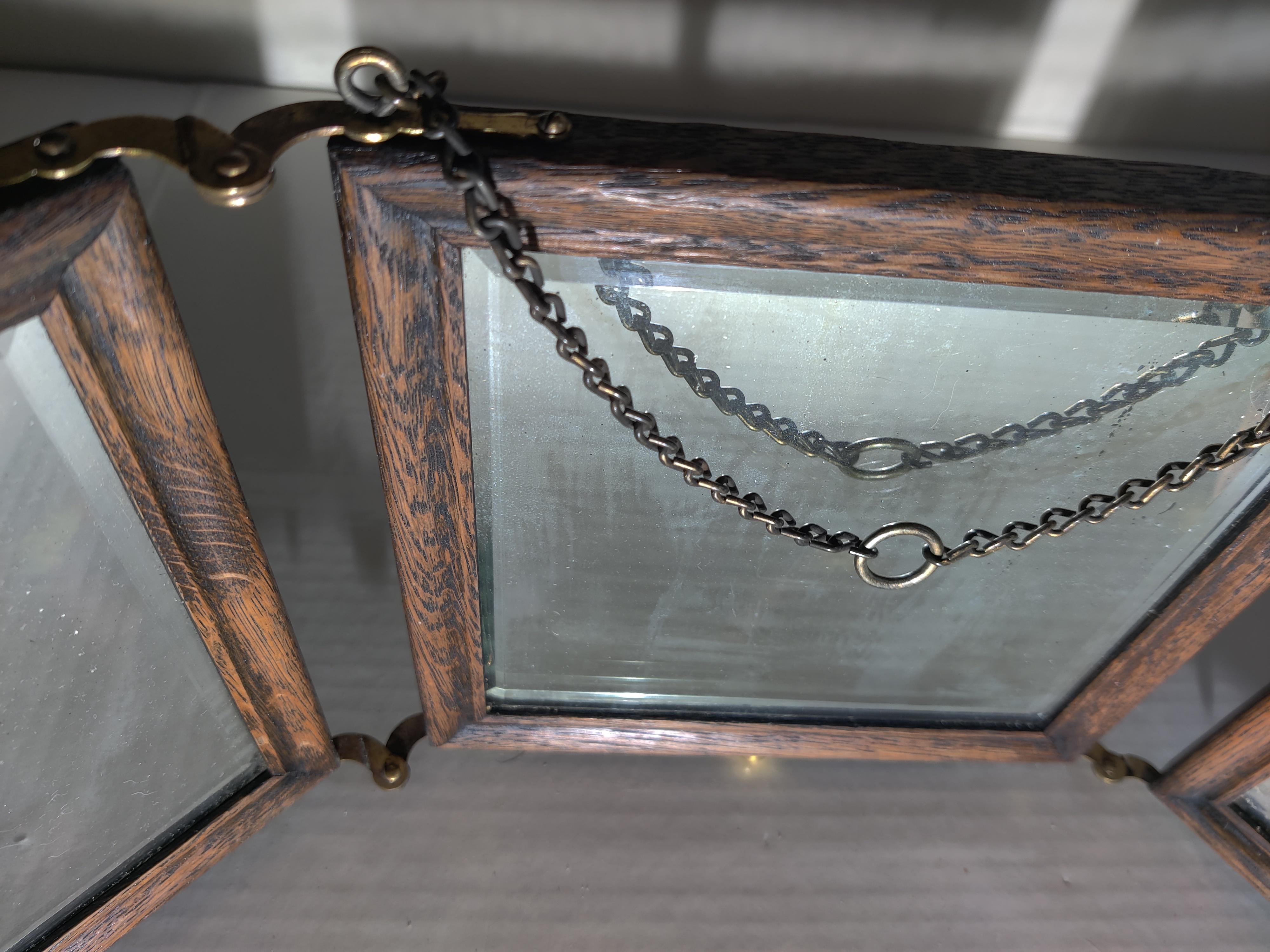 Antique English Victorian Tri-Fold Vanity Mirror 
Beveled Mirrors with beautiful pattern on back of each mirror.   
Oak frame with brass hardware and brass chain.
8