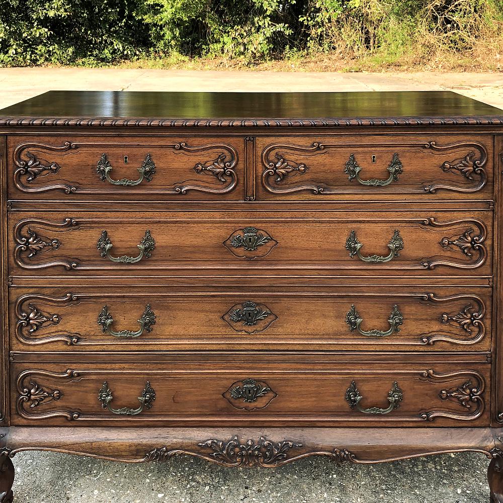 Antique English walnut Chippendale commode features timeless lines, the sheer natural beauty of the wood, and finely carved accents across the entire facade, and even on the rolled apron with floral and foliate motifs complementing the boldly