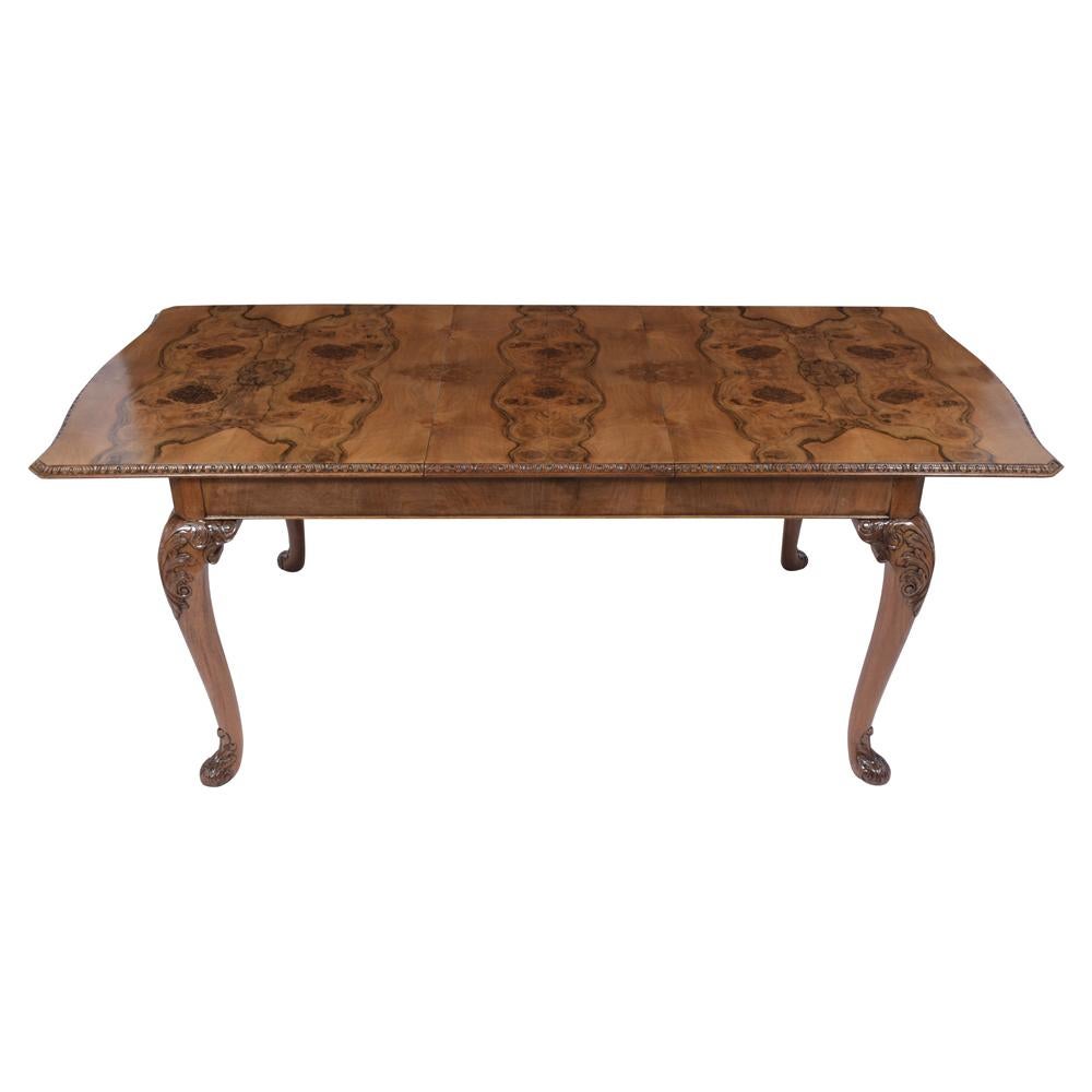An extraordinary Queen Anne dining table handcrafted out of walnut wood with a newly lacquered finish has been professionally restored. The writing table features an extendable top with two leaves fully covered with beautiful organic walnut design