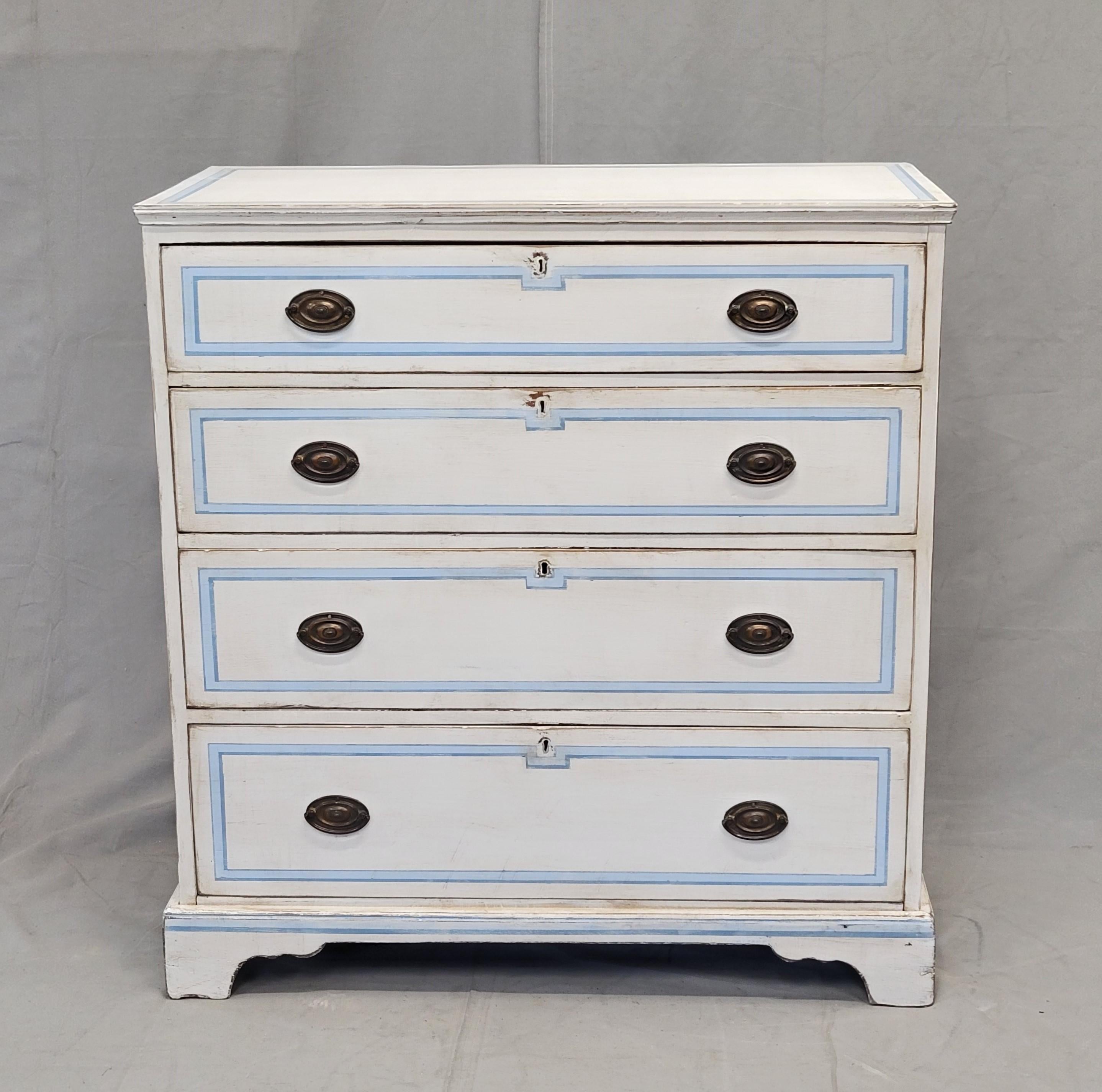 An elegant and functional antique circa 1900 English walnut dresser with bracket feet, painted white and accented in a blue French line motif. Note the distressed areas in the paint, see photos. Coppery brass pull rings add to the elegance of this