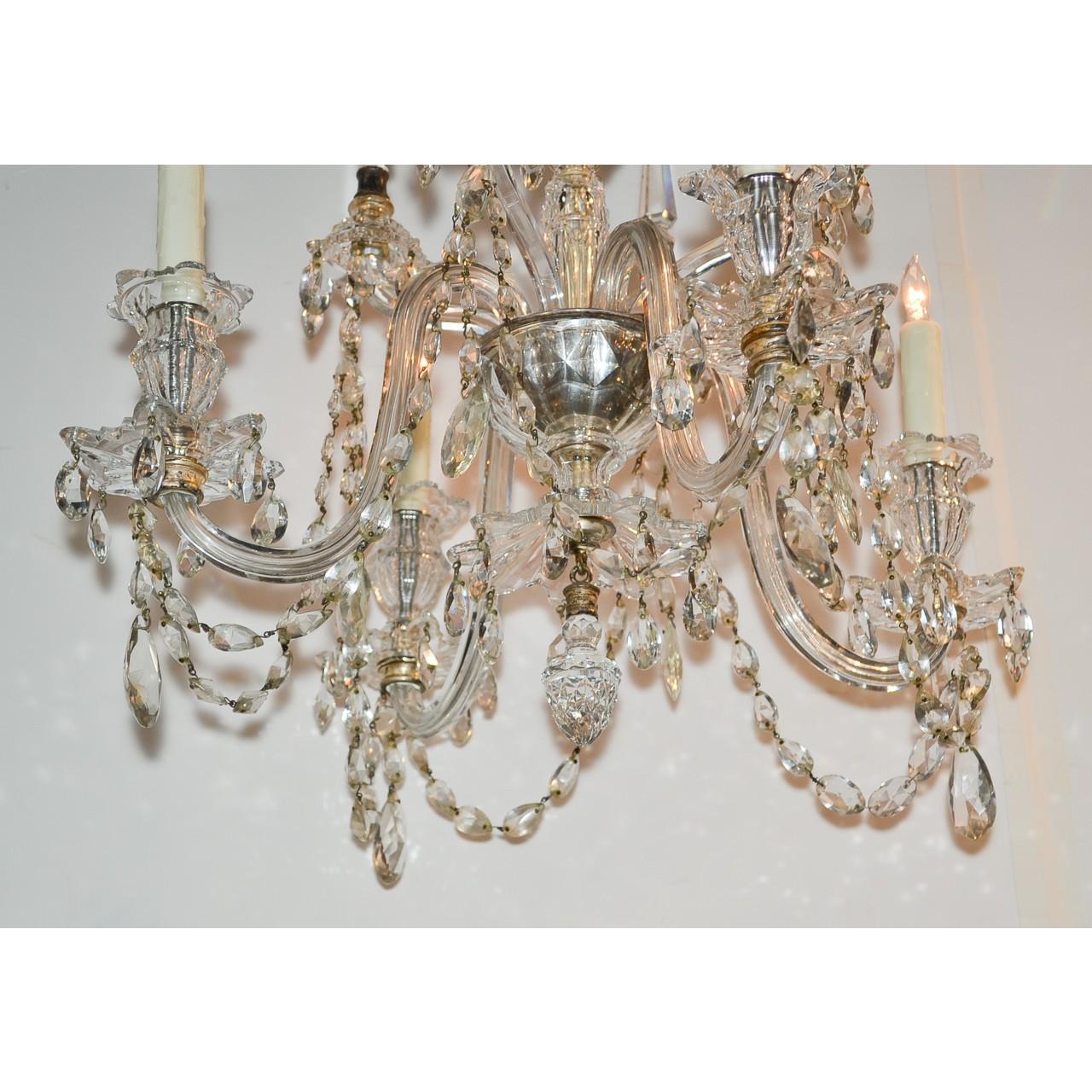 A dazzling antique English Waterford style crystal chandelier of paragon quality. The domed-shaped cut crystal crown with dangling strands of pear-shaped prisms. The shaped cut crystal stem mounted with gracefully contoured arms with star-shaped