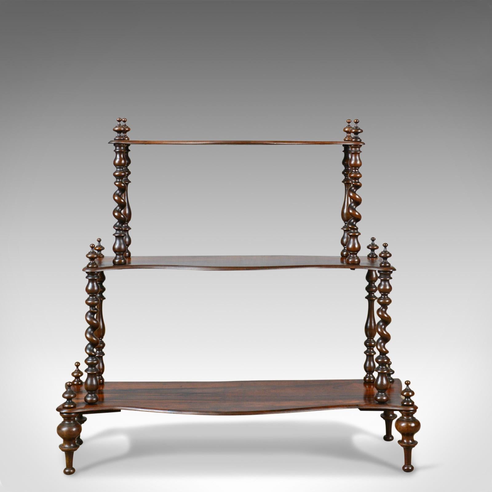 This is an antique whatnot, an English, Regency, rosewood, three tier display stand dating the early 19th century circa 1820.

Attractive, well figured rosewood, graduated shelves
Serpentine display shelves in waterfall form
Good colour