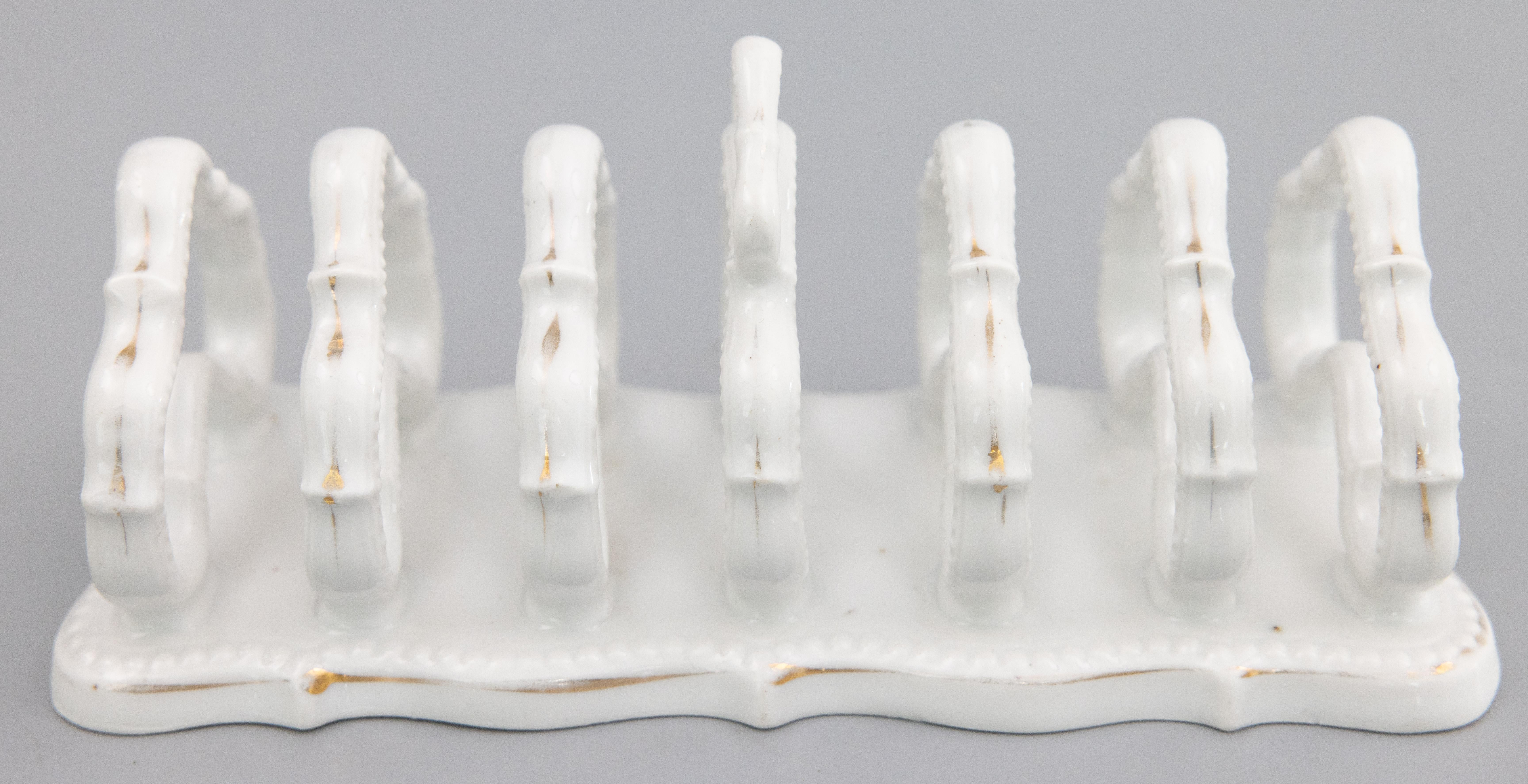A lovely antique English white ironstone six slice toast rack, circa 1910. This beautiful toast rack has lovely gilt accents, beaded edge, and scalloped design. It would be wonderful for serving toast or could also be used as a letter