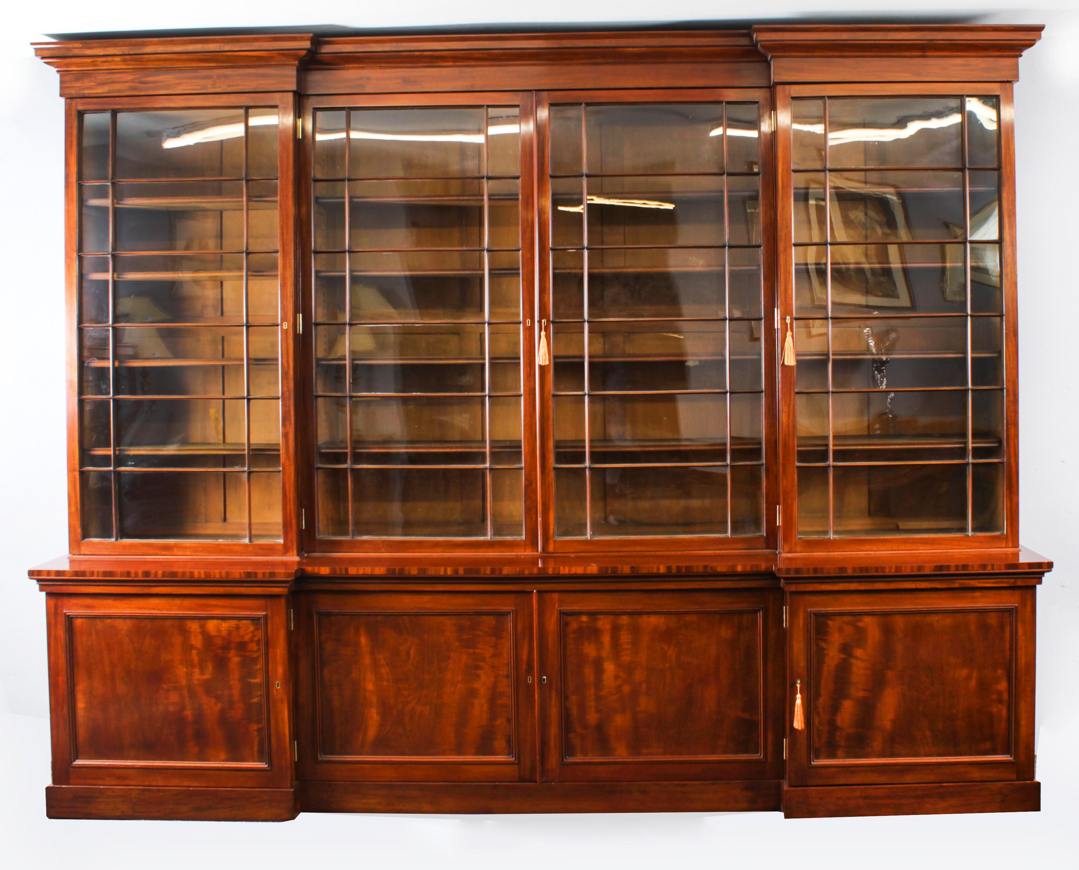 This is a beautiful antique William IV four door inverted breakfront library bookcase, masterfully crafted in rich solid flame mahogany, Circa 1830 in date.

This magnificent bookcase features a moulded cornice above four square astragal glazed