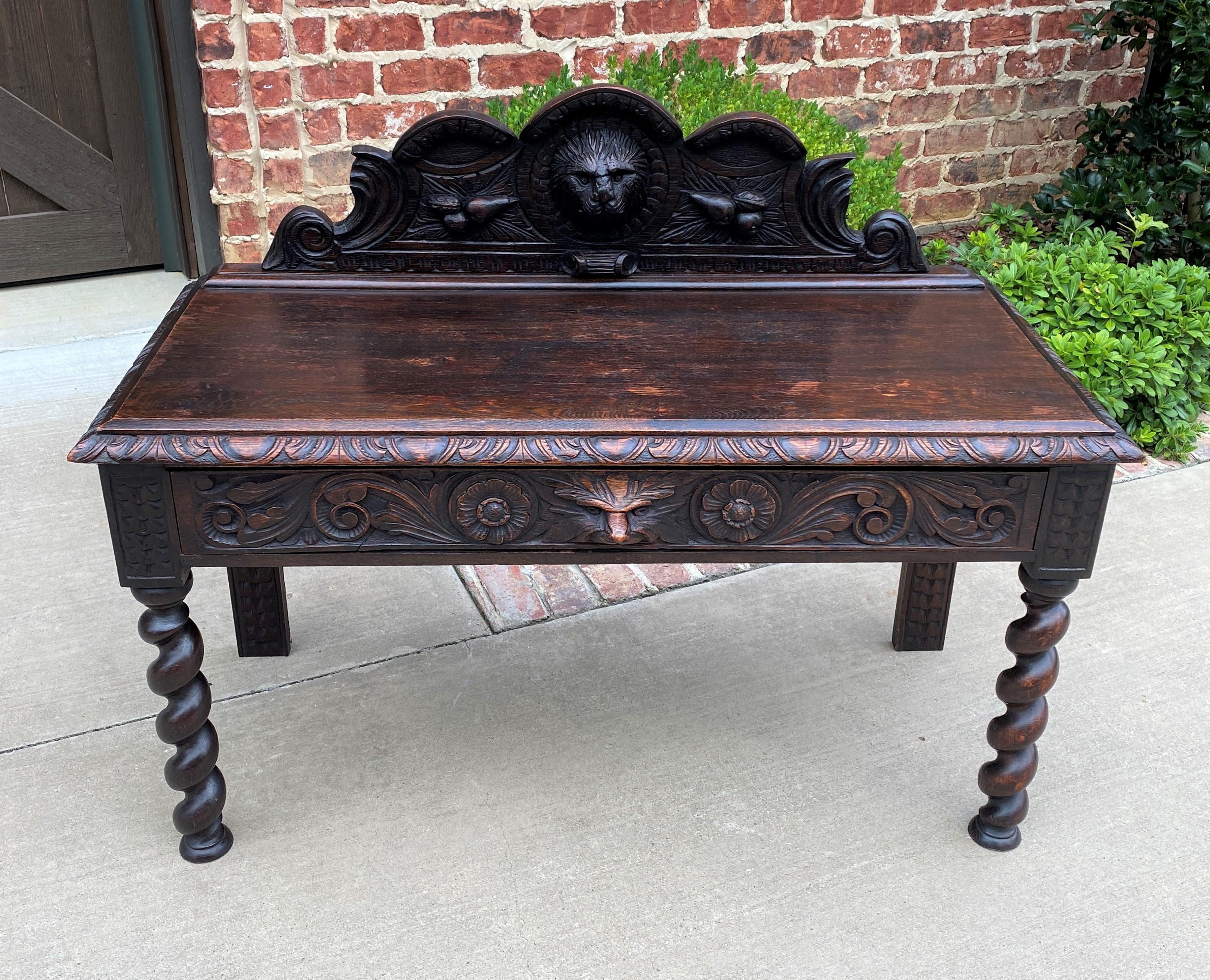 Charming antique English oak window seat or end-of-bed bench~~Gothic revival~~one drawer ~~c. 1900

Classic British flair decorator piece~~highly carved crown with gothic elements and barley twist legs~~one wide drawer for storage with carved mask