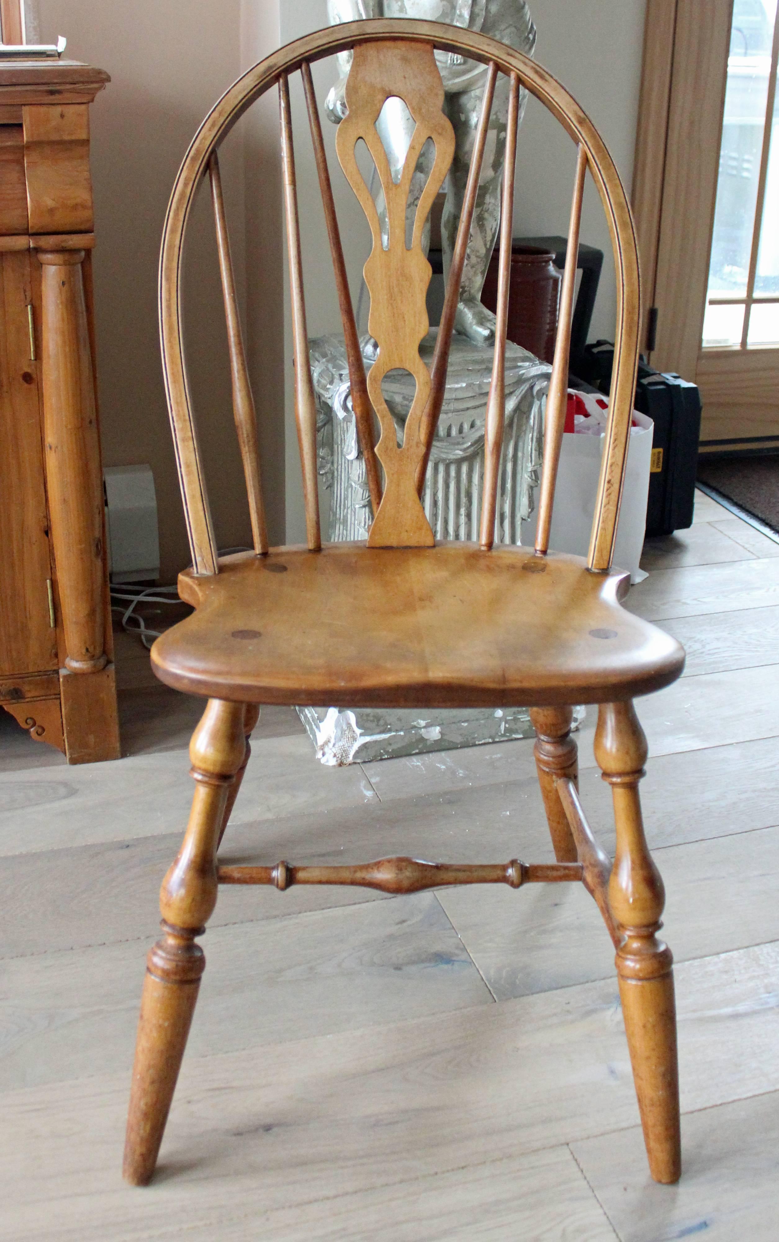 Eight fine English Windsor bow-brace back dining chairs with decorative splat and finely turned legs and stretcher, in ash with coordinated host and hostess chairs with rushed seating details.