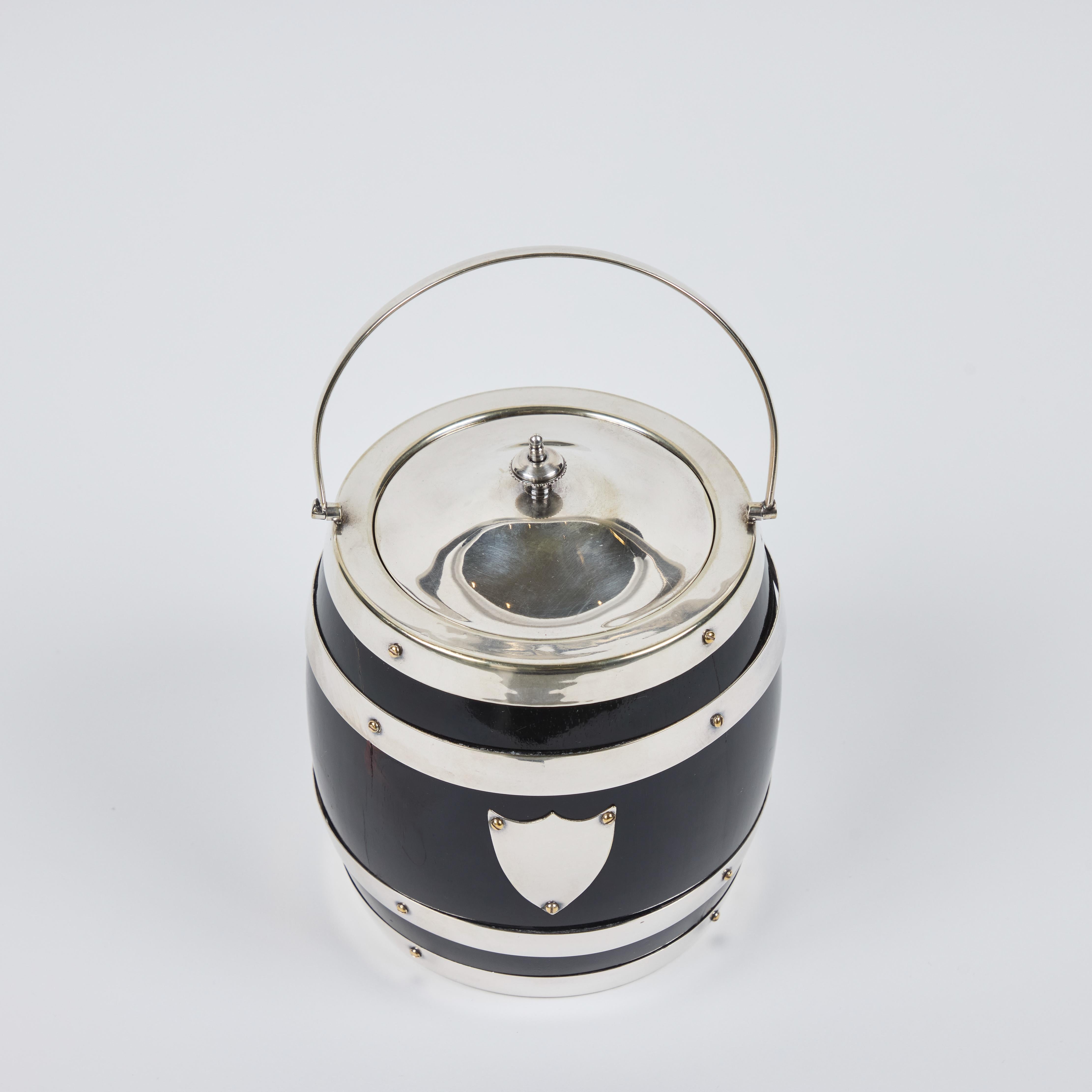 We adore this dazzling antique English wood biscuit barrel with a white porcelain lining. It has stunning shiny silver plated accents. This would be a wonderful addition to any bar, shelf or table.

  5.5