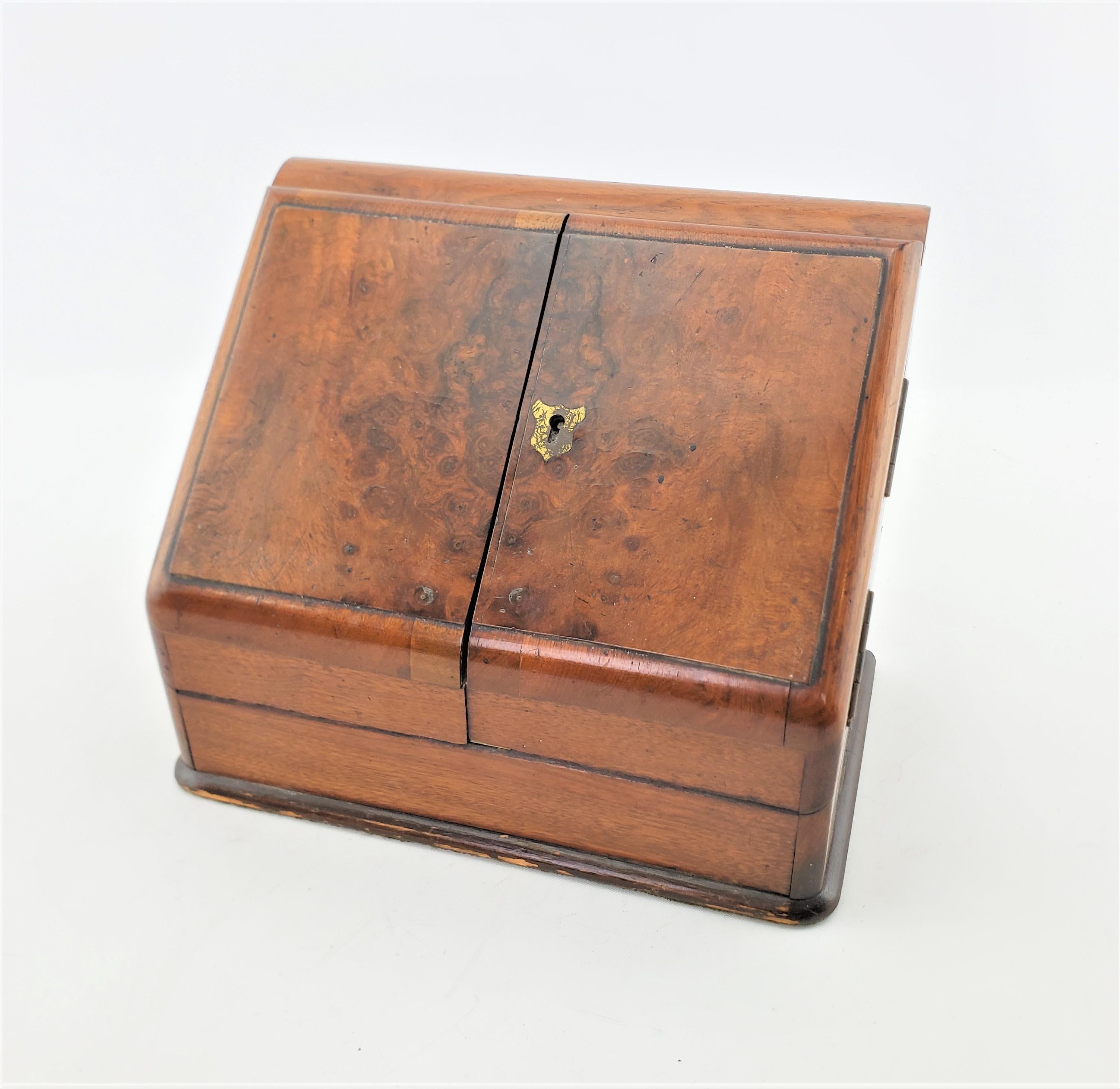 This antique lap desk and document box is unsigned, but presumed to have originated from England and date to approximately 1825 and done in the period Early Victorian style. This small travel sized lap desk is made of wood with brass hinges and