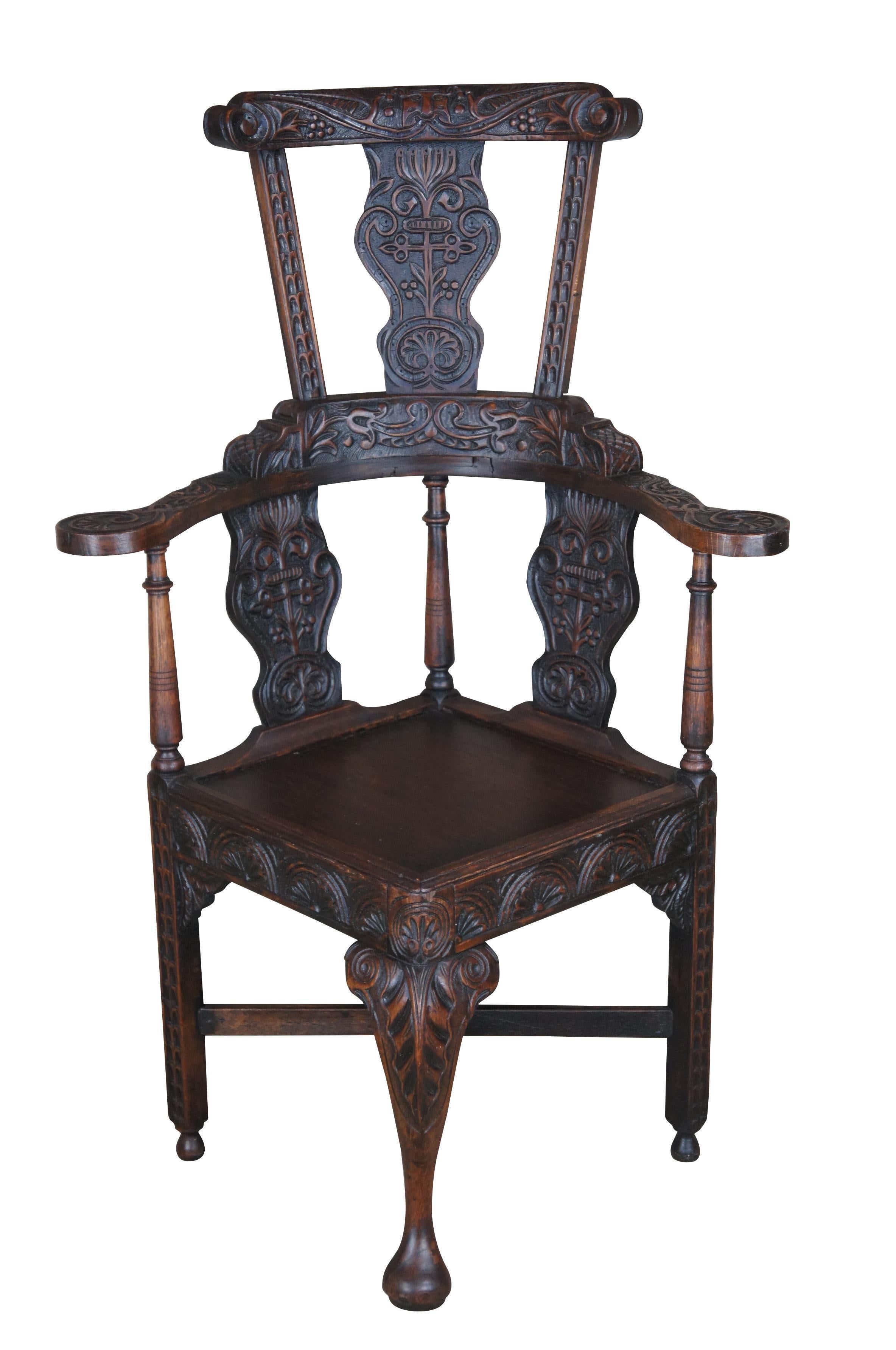 Exceedingly Rare English Yorkshire Wainscot High back corner armchair, circa 17th century.  Made of oak with an impressive hand carved back that features a whimsical figure along the crest over a foliate and berries motif, C and S scrolls, turned