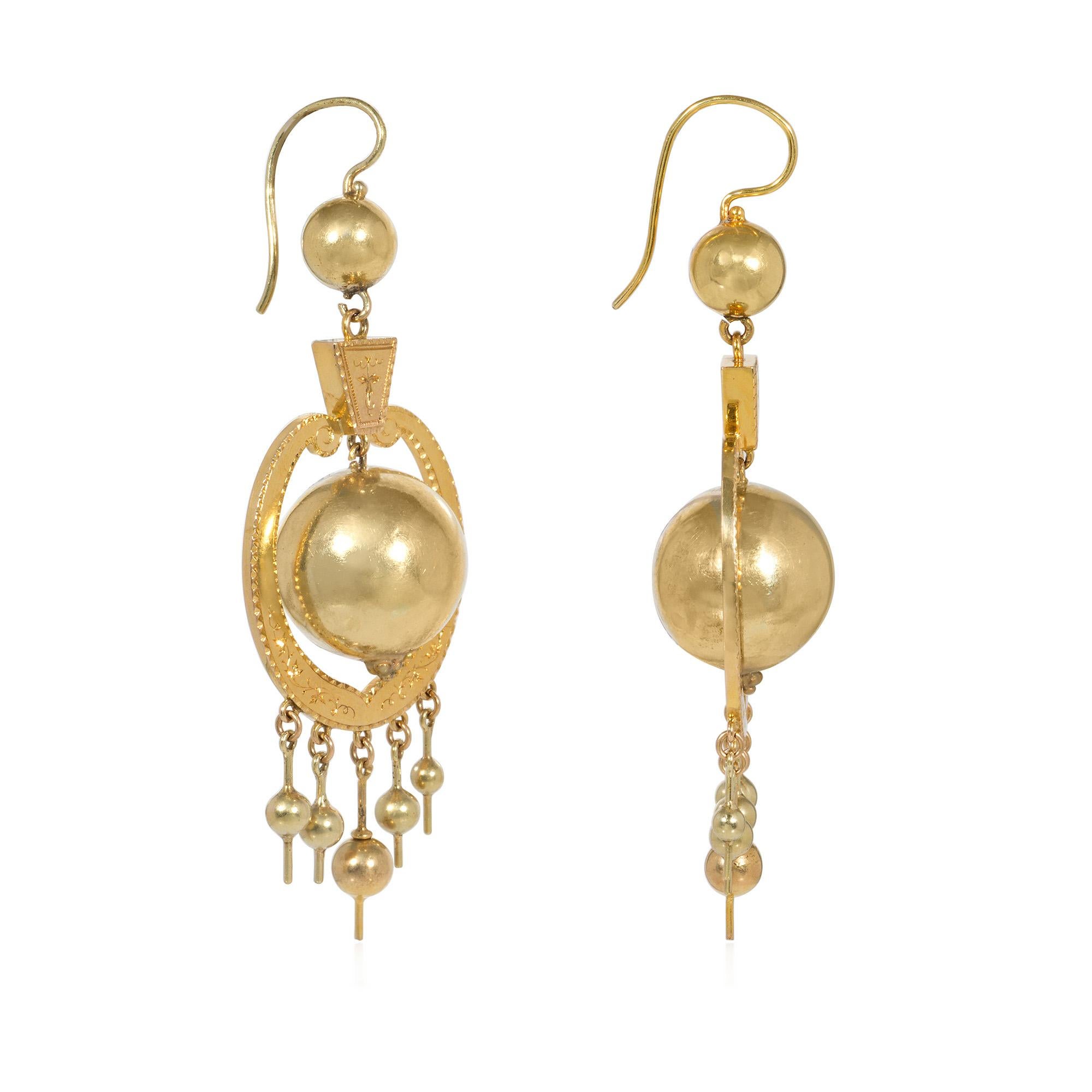 A pair of Antique Victorian gold pendant earrings comprised of oversized gold beads in lyre-shaped hand engraved floral frames with five beaded fringe terminals and bead surmounts, in 14k yellow gold.


* Free shipping
* Includes letter of