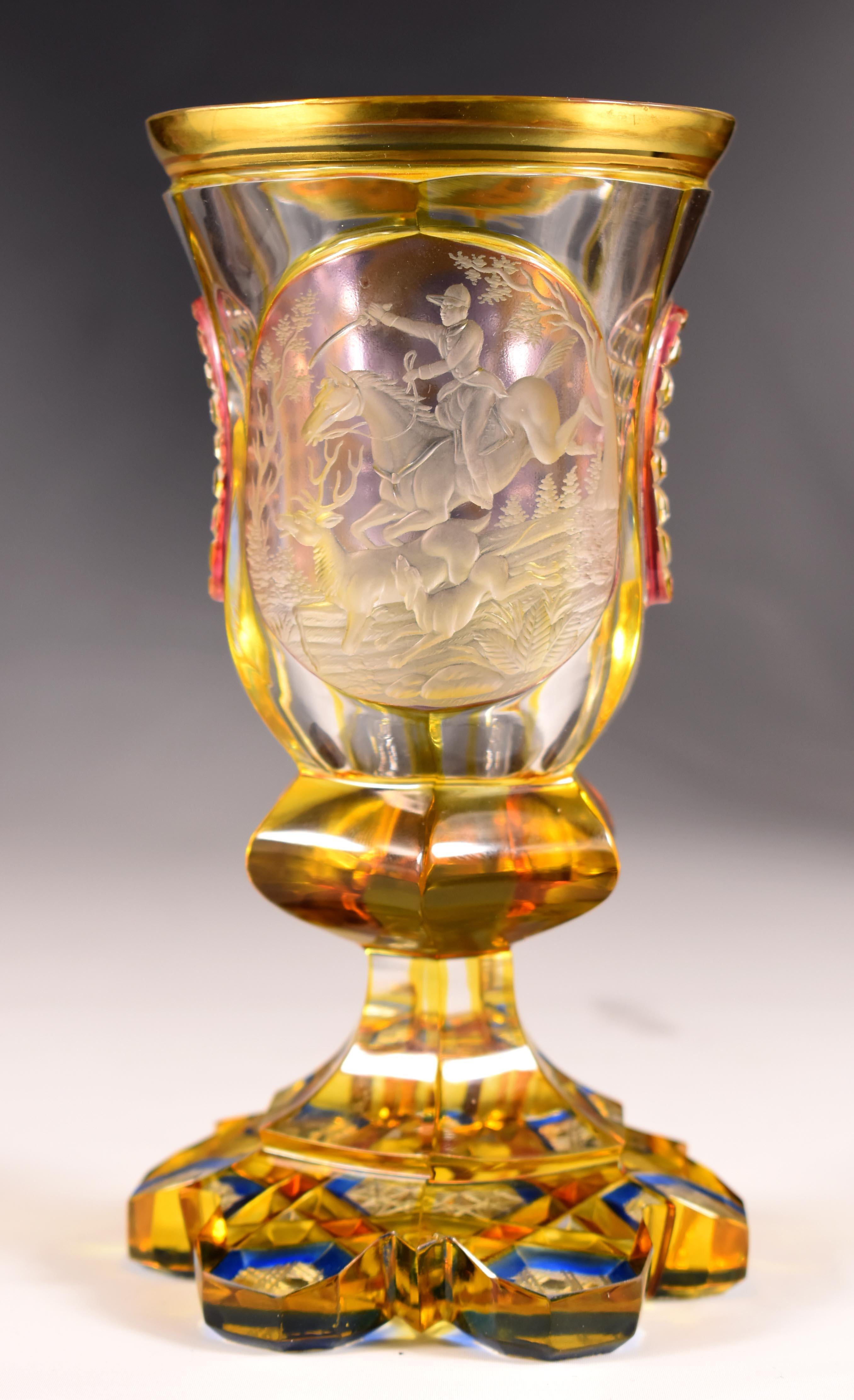 Beautiful antique cut goblet with yellow lazure, the yellow lazure is supplemented with transparent colors, In one of the two medallions there is an engraving with a hunting motif, It is a rider on horseback with a hound and a deer, A very popular