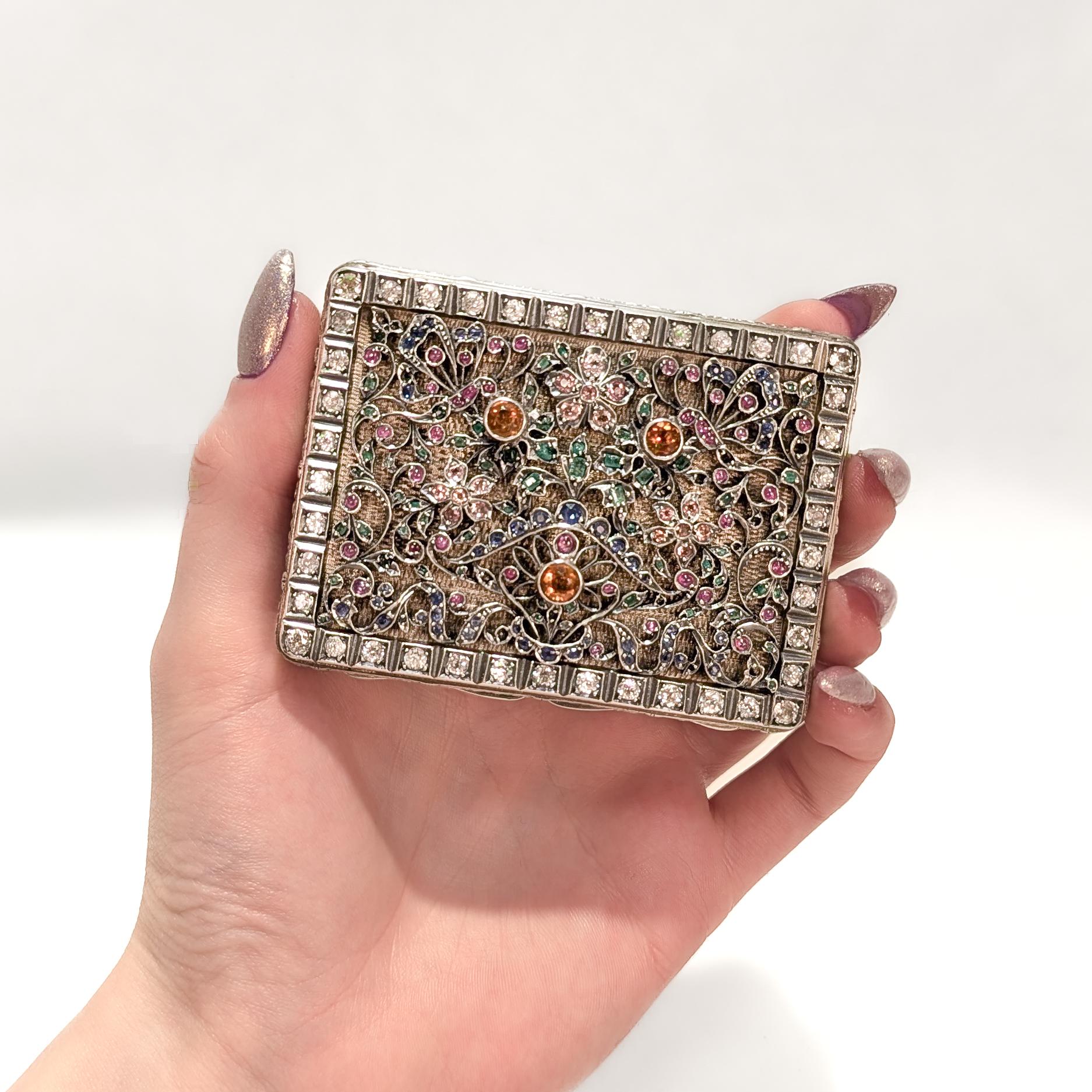 Une belle boîte ancienne en argent et incrustée de bijoux.

En argent massif.

Le couvercle est décoré d'un fil métallique floral et incrusté de multiples pierres précieuses.  comprenant des rubis, des citrines, des tourmalines, des topazes et des