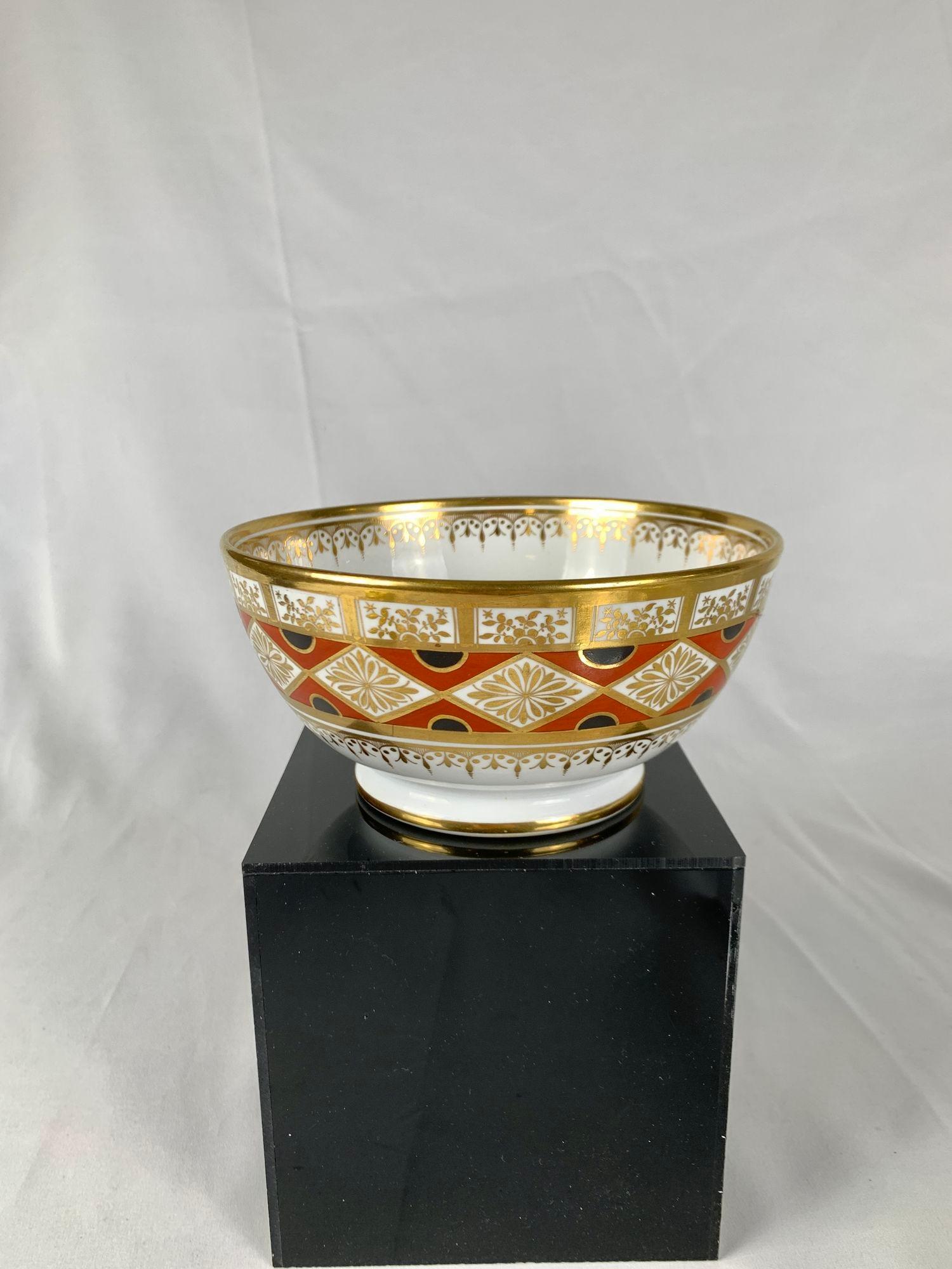 Diese elegante antike Porzellanschale wurde um 1820 bei Coalport Porcelain in England handbemalt.
Die Schale zeigt leuchtende Farben: orangefarbene Dreiecke, die mit schwarzen Halbkreisen gefüllt sind, und eine üppige Vergoldung.
Neben den Farben