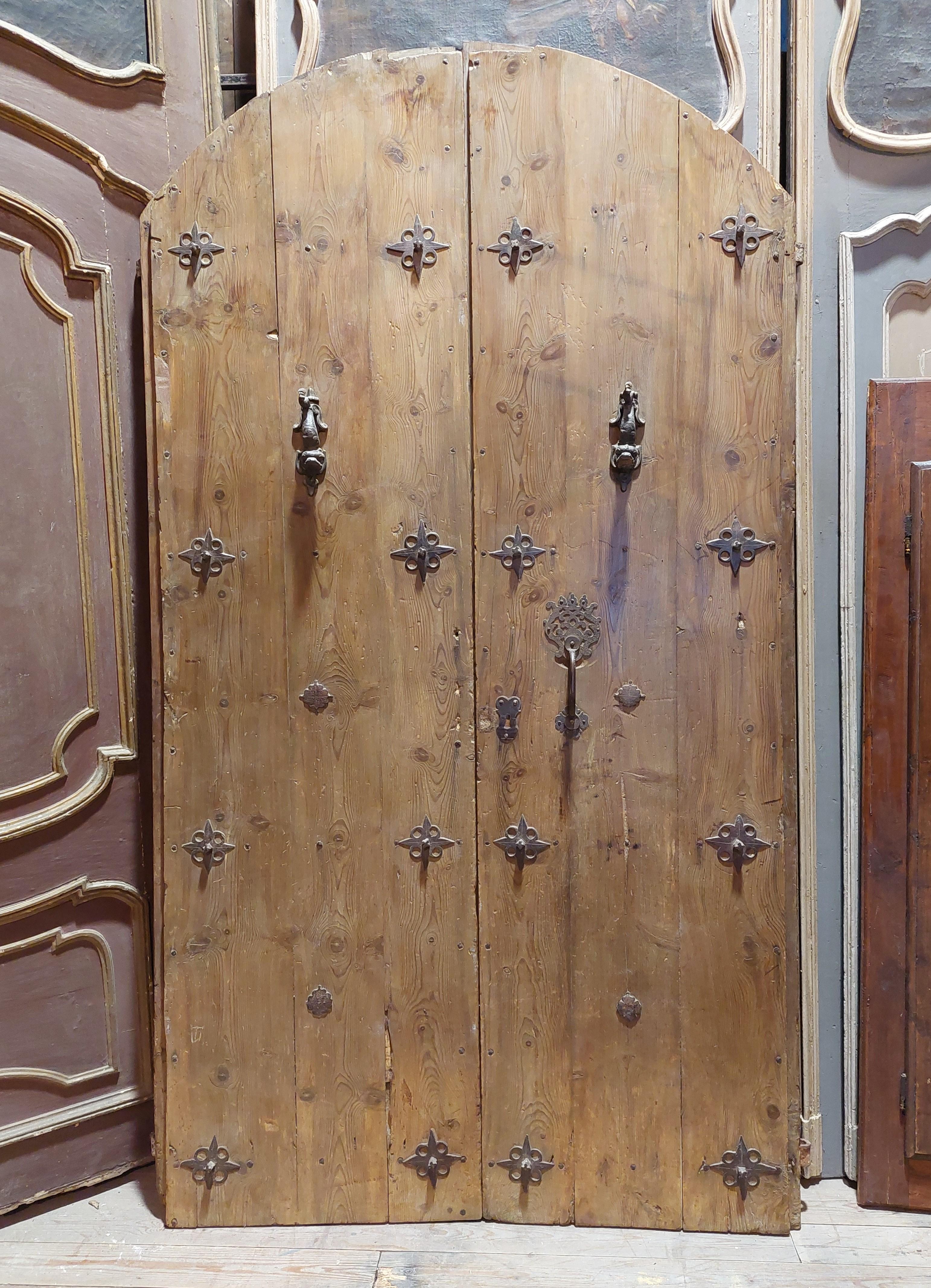 Ancient entrance door in larch, double-wing main door, rounded at the top, decorated and formed with beautiful original irons and studs carved in antique iron, built for a luxury rustic hunting lodge in northern Italy, in the 18th century .
Ideal