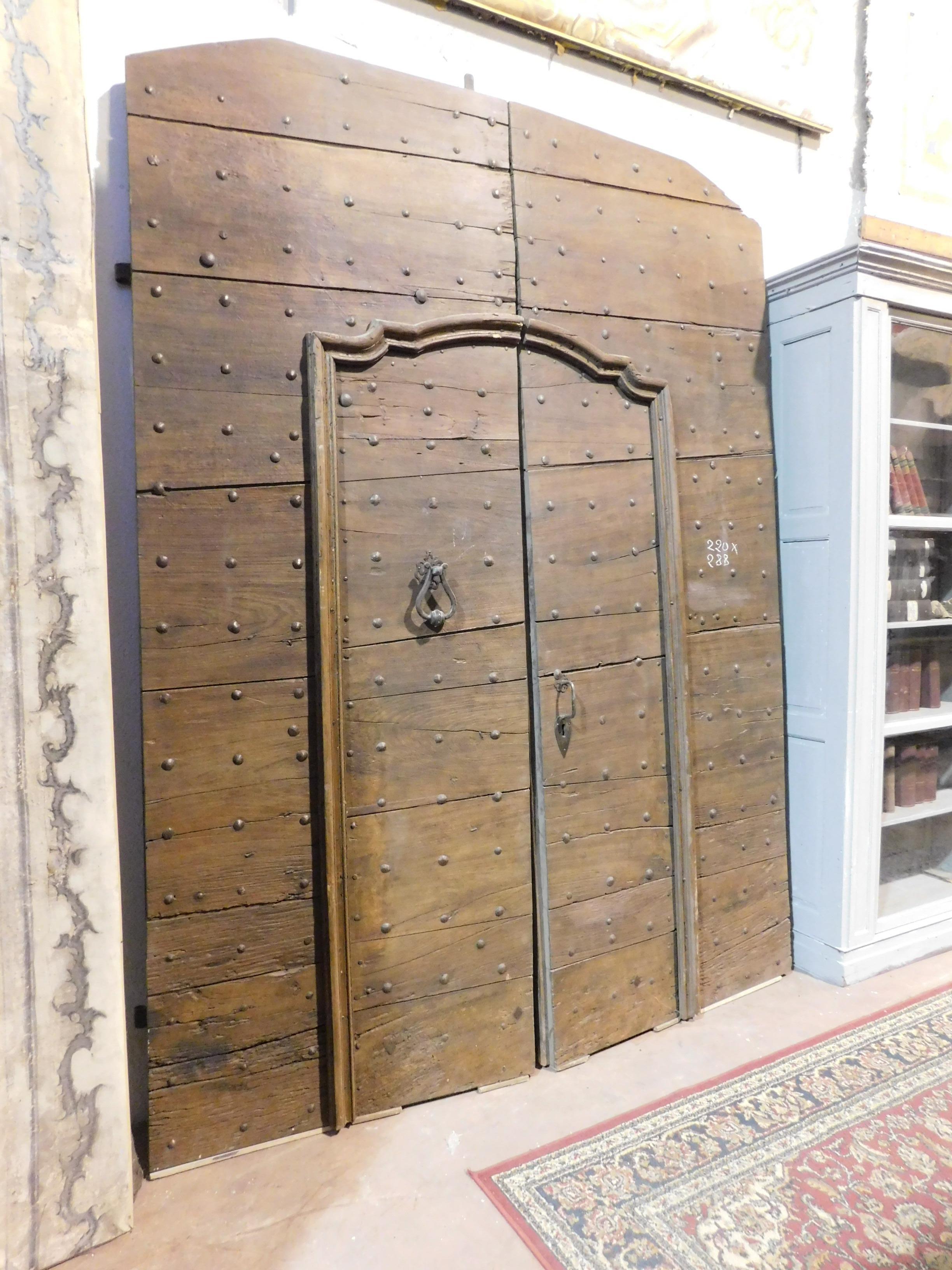 Ancient entrance door, main door, built entirely by hand with precious walnut wood, with a nailed finish as was the style of the time, opens with two large wings and has a small internal door, built in the 18th century for a palace in the north
