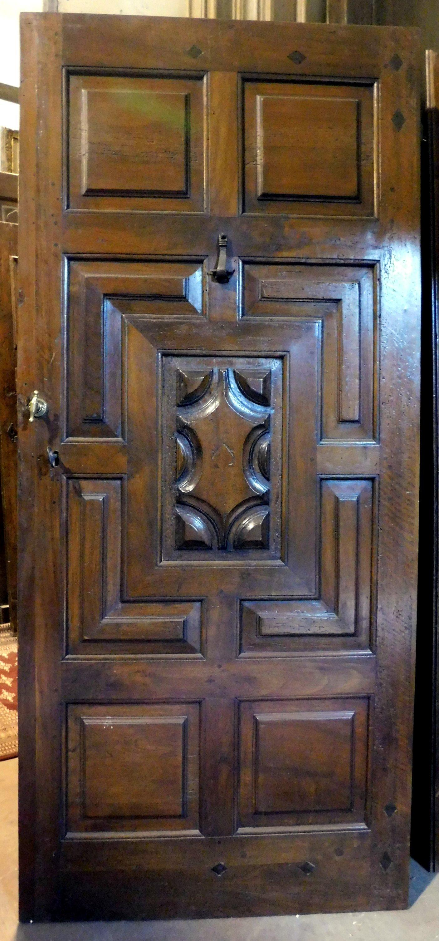 Ancient entrance door, main door, built by hand in precious walnut wood carved by hand with tiles of the time, from the beginning of the 18th century, built for the entrance of a villa in the historic center in northern Italy, from Saluzzo