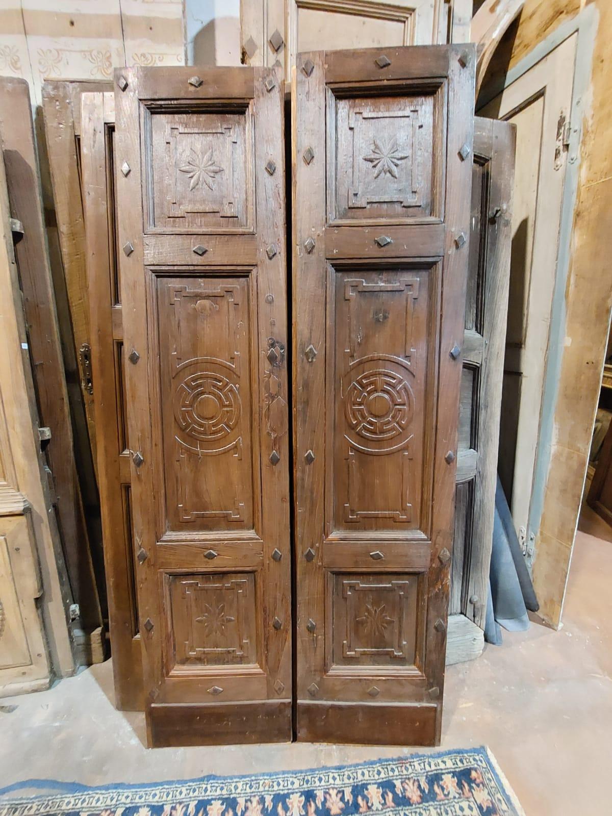 Antique double-wing entrance door, hand-carved in solid walnut with carved tile decorations, built in the middle of the 19th century for a palace entrance in northern Italy.
Well patinated, it has a smooth back and original irons, it was hung