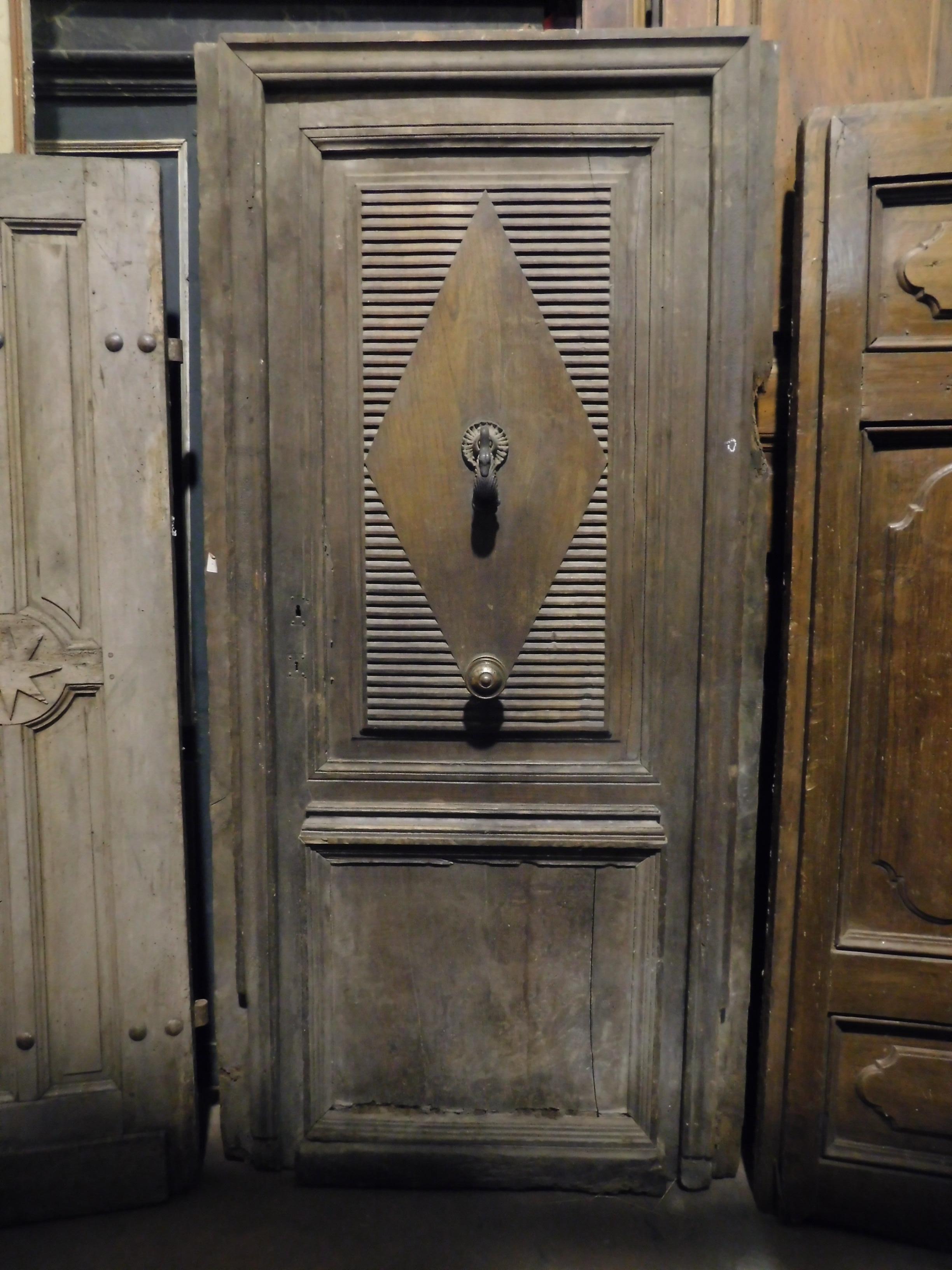 Ancient entrance door, main door, with original frame, original knocker and knob still present, hand carved in precious patinated walnut wood, fascinating period that makes it very beautiful in color, handmade in the 19th century in Italy.
Of great