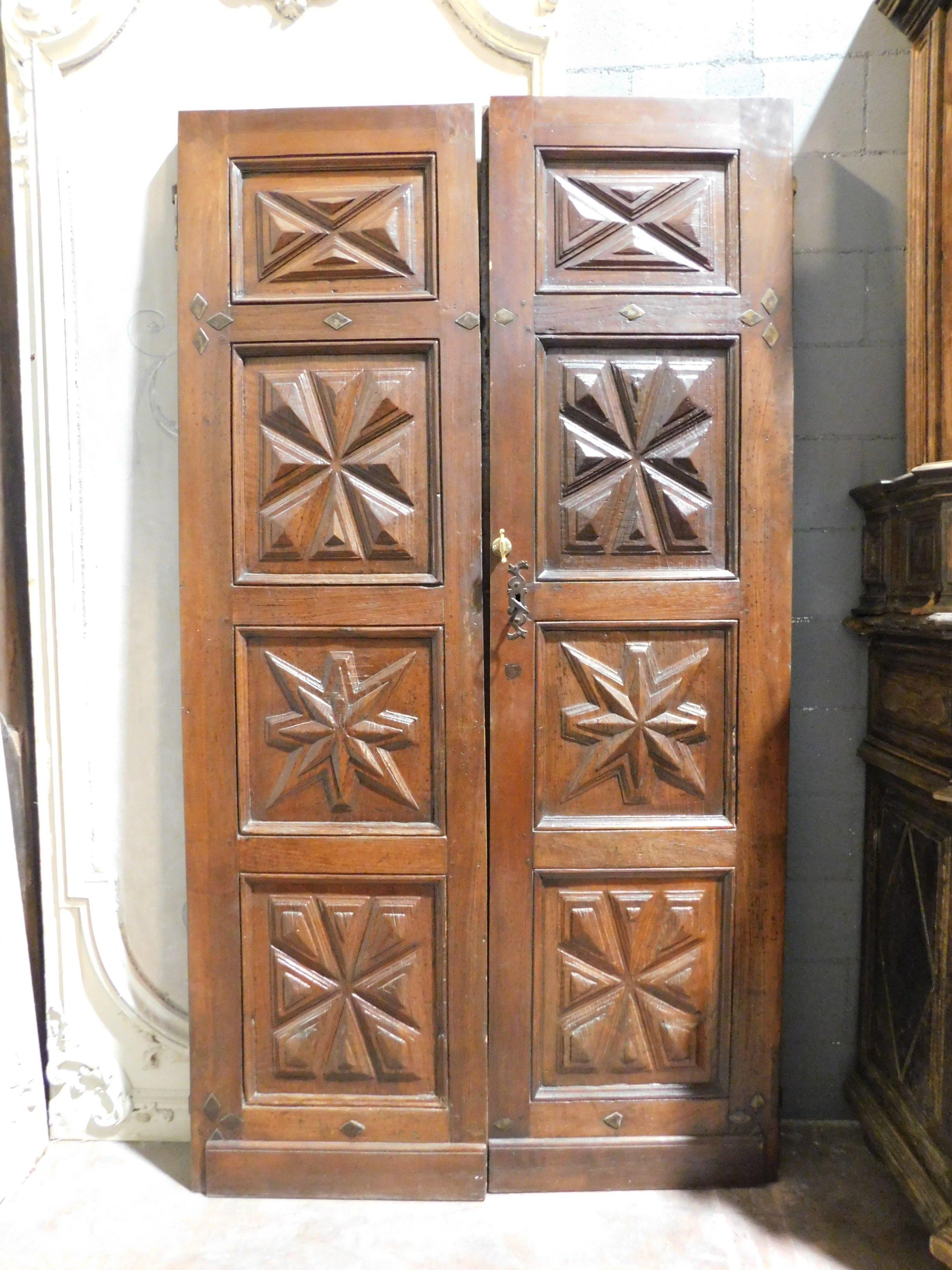 Antique entrance door, double-winged, hand-carved in walnut with diamond design panels, built in the 17th century in Italy.
Entrance door of a probable noble house in the Italian historic center,
very precious, diamond design that few wealthy