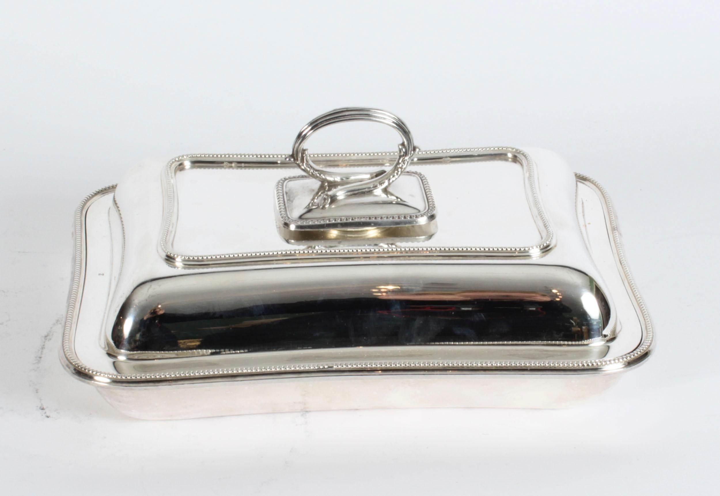 This is an exquisite and rare antique English silver plated entree dish, bearing the cross arrow mark of William Hutton & Sons, circa 1850 in date.
 
The entree dish features a rectangular shape with elegant beaded decoration to the dish, lid and