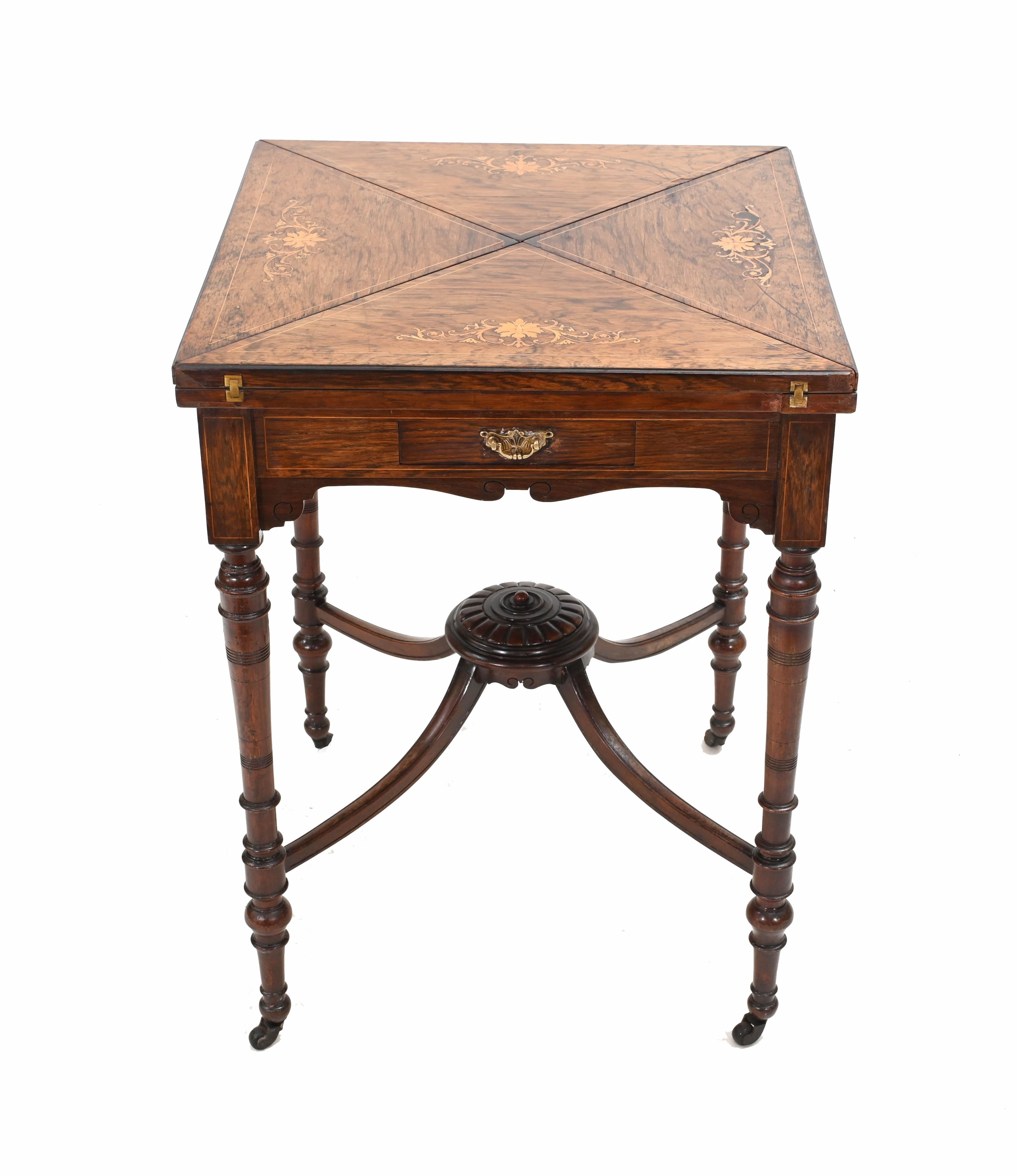 Refined Edwardian games table
Also called an envelope table due to the manner in which it opens out
Hand crafted from rosewood with intricate inlay work
Opens out to reveal game playing surface 
Circa 1910
Some of our items are in storage so