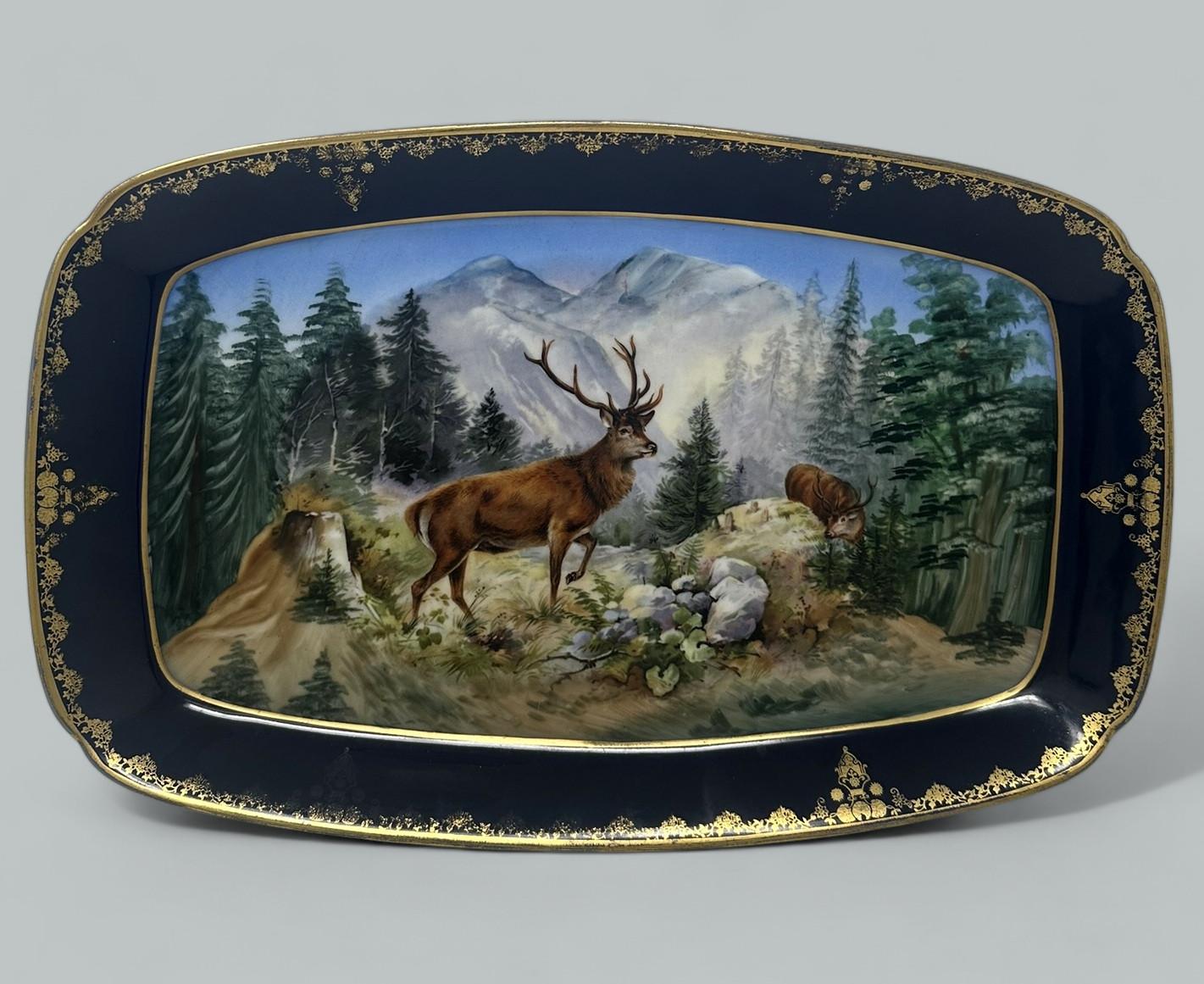 Impresionante ejemplo de bandeja, plato o mueble decorativo de porcelana pintada a mano de contorno rectangular, finales del siglo XIX, fabricado por Royal Epiag Checoslovaquia. 

Magníficamente decorada, representa una escena de bosque que incluye