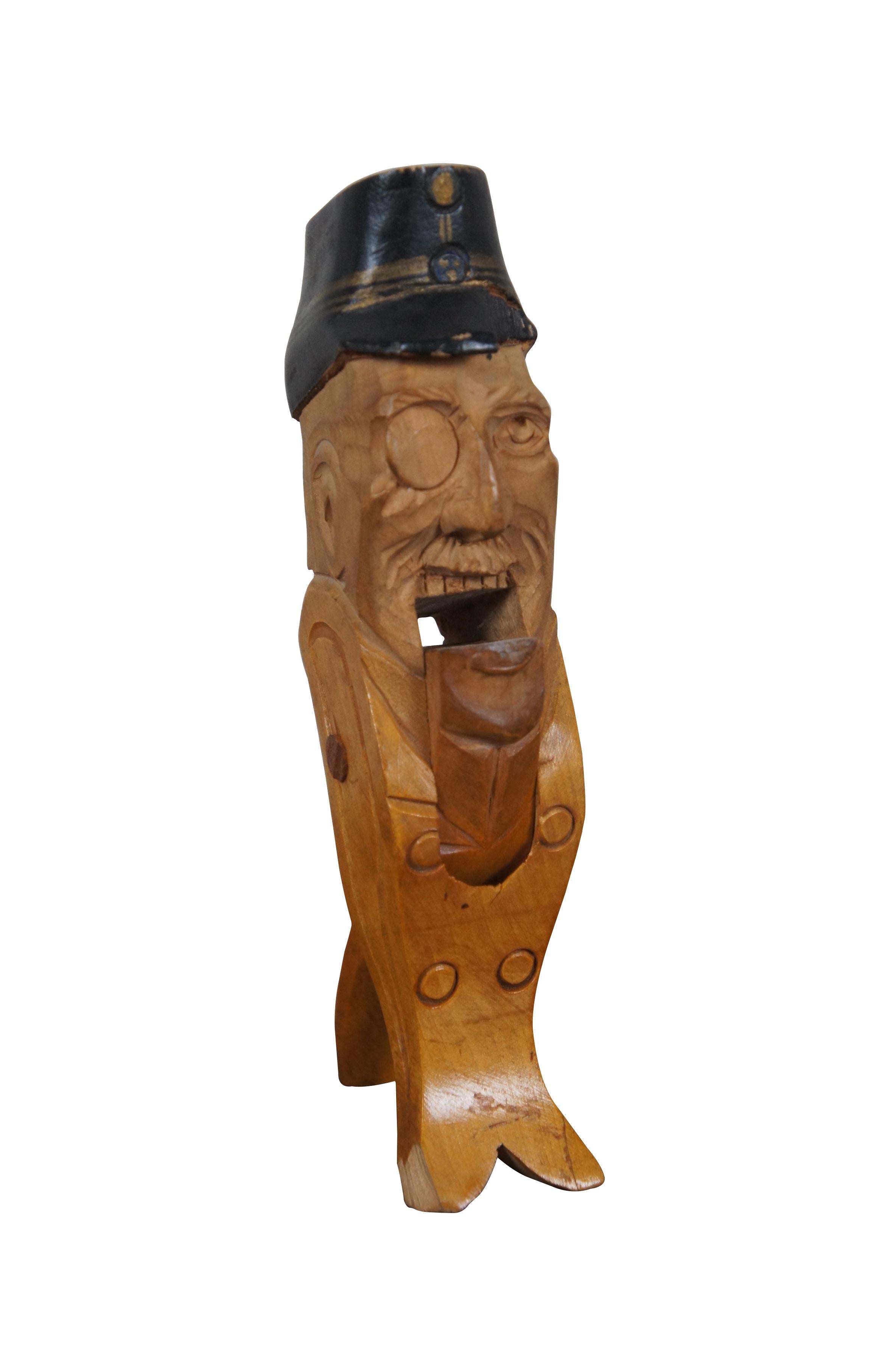 Antique Erik Molin (Swedish 1855-1933) hand carved birch nut cracker (Nötknäckare).  Depicts an elderly man with moustache and monacle / eyepatch, wearing a double breasted coat and military style cap. The base of his torso terminates in a fish