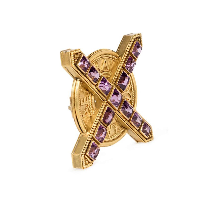 An antique gold brooch in the Etruscan Revival style comprised of a rectangular-cut amethyst 