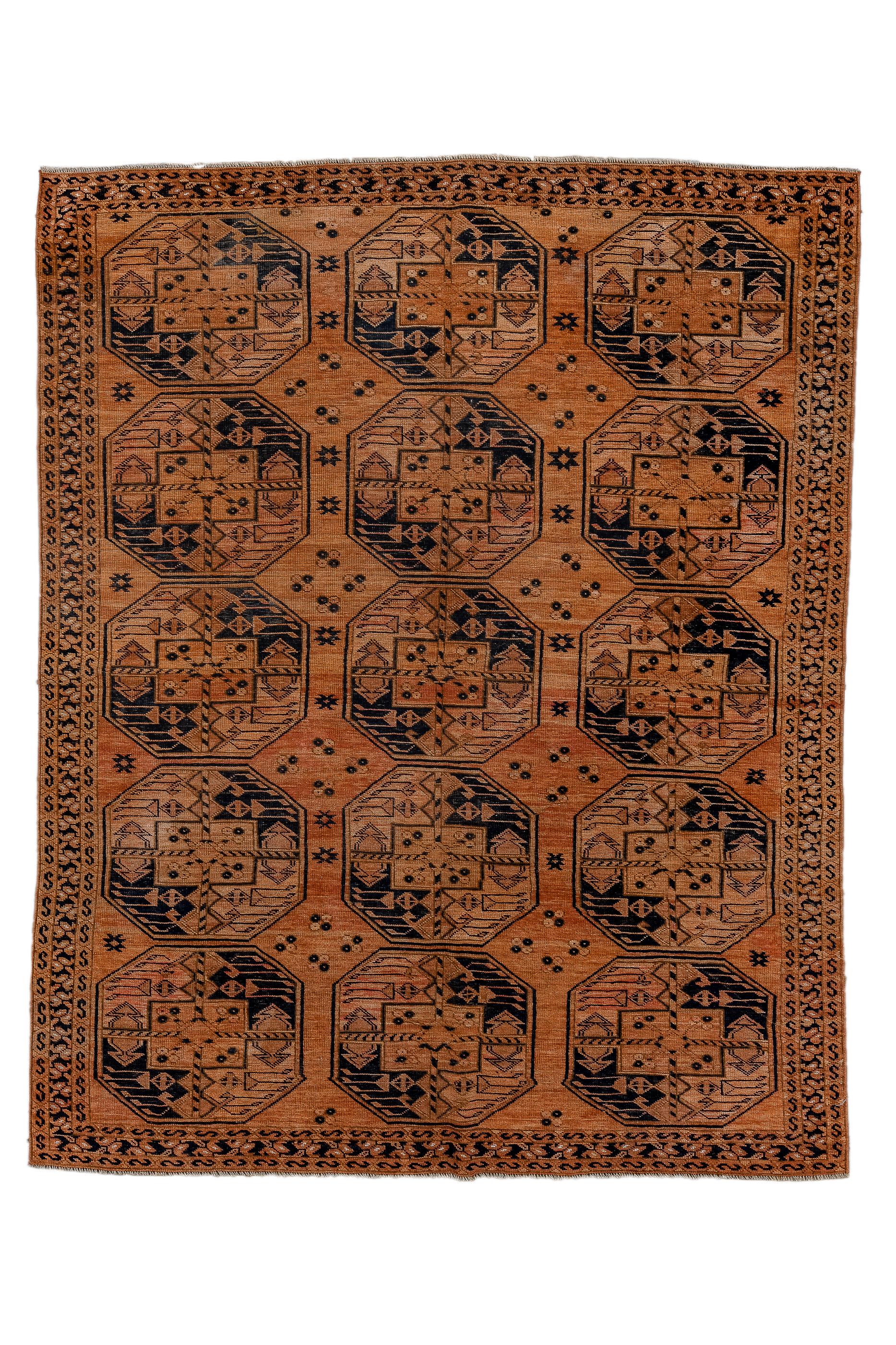 The abrashed rust field shows three columns, each of  five closely spaced octagonal Turkmen “Daulatabad” guls, quartered in  near black and light rusty brown.  Quartets of small, divided squares act as minor gul devices between the larger elements. 
