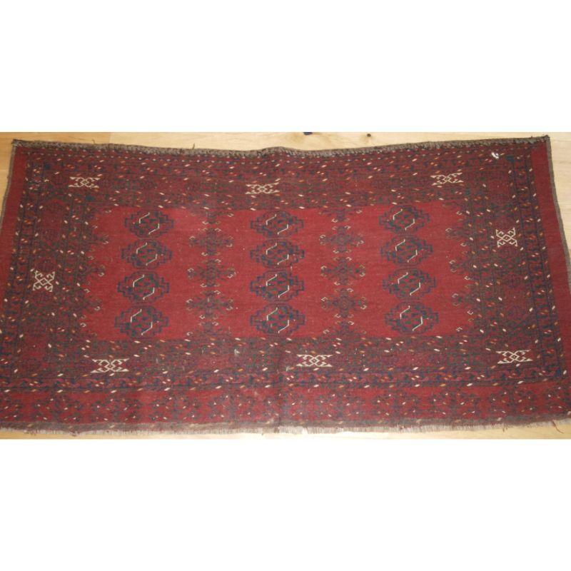 Antique Ersari Turkmen 12 gul chuval of large size, with clear red colour. The chuval has 3rows of 4 Ersari chuval guls. The elem design is a stylised tree design.

Slight even wear with good pile. The chuval has a firm weave and will stand up to