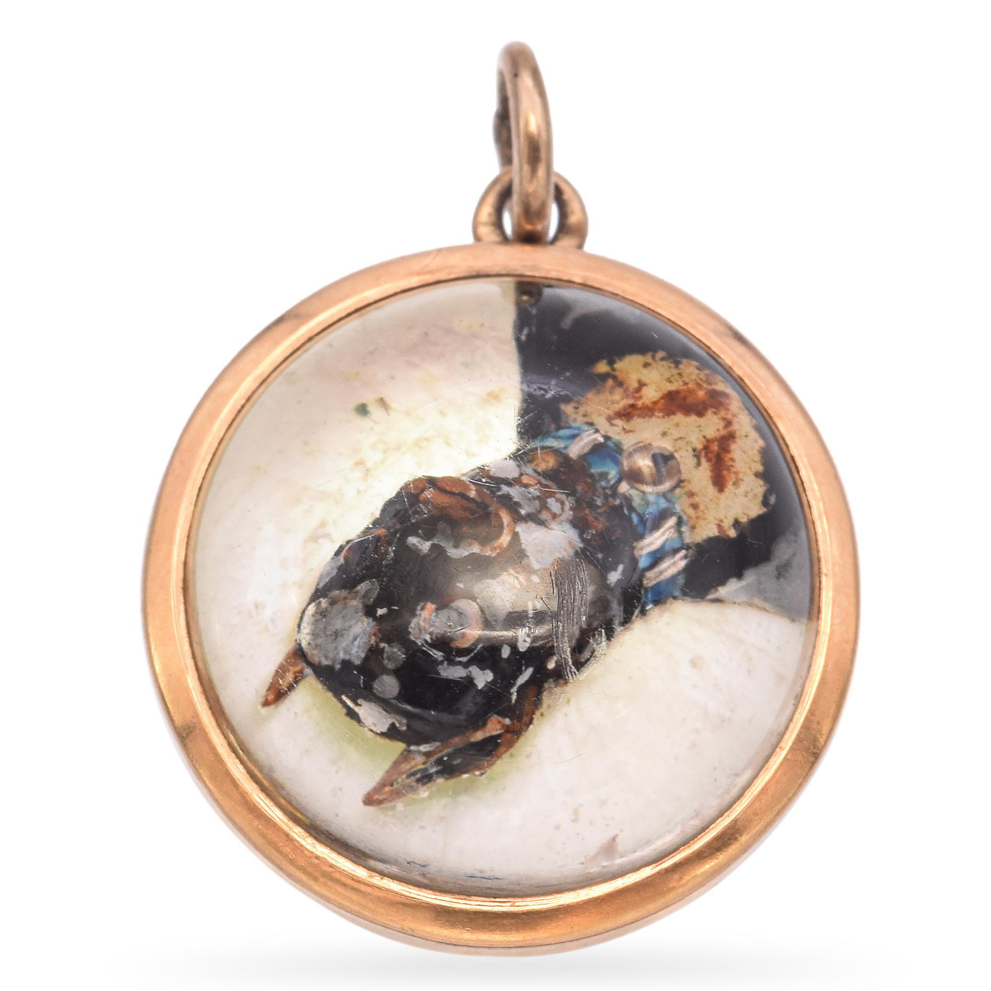 Ein Charme aus der Mitte des 19. Jahrhunderts, gefertigt aus 9k Gold, mit einer detaillierten Darstellung eines Hundes unter einer Glaskuppel.

Gewicht: 4,4 Gramm 
Abmessungen: 17,3 mm Durchmesser 
Metall: 9k Gelbgold
