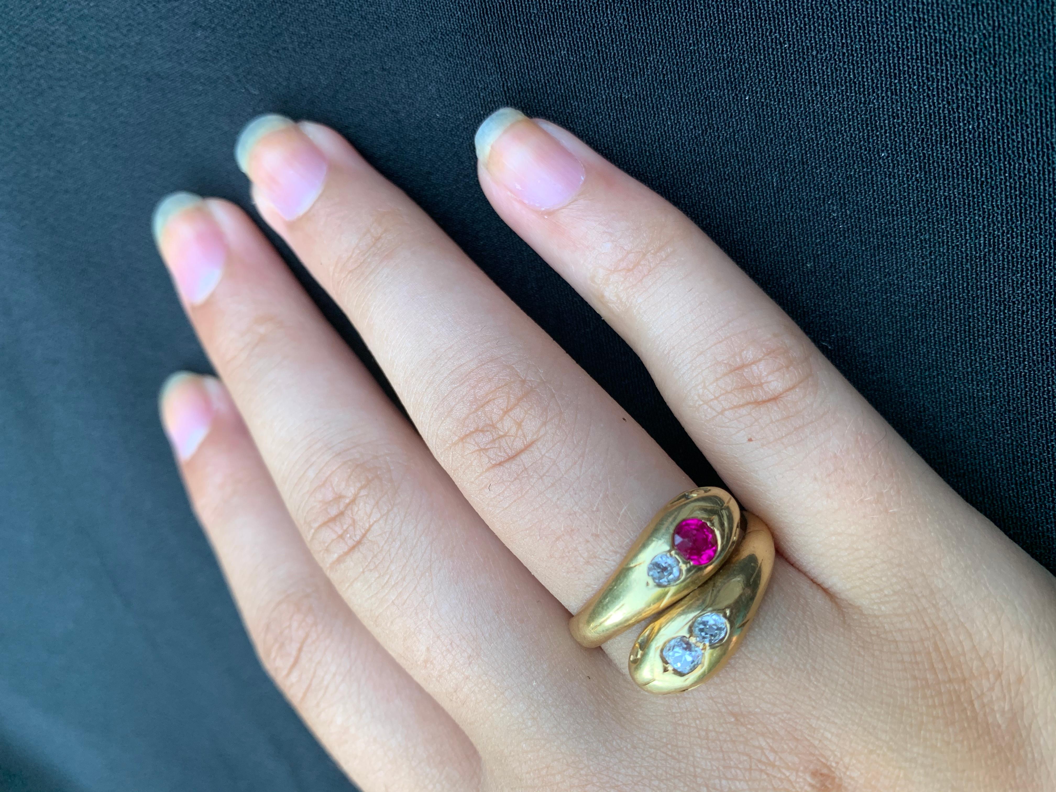 Large, solid quality antique French 18K gold double snake ring. The snakes are well detailed, one is set with two round diamonds, the other with a diamond and a synthetic ruby, eyes are done in gold with each snake having a slightly open mouth.