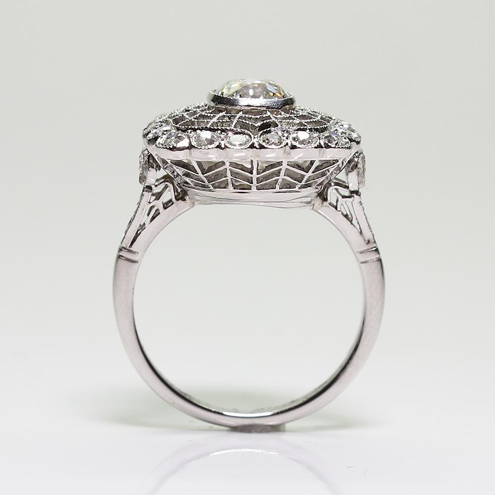 Antique estate platinum diamond Edwardian style engagement ring. Showcasing one Old Mine cut diamond in the center weighing approximately 0.95 carats, having J color grade and VS1 clarity grade. Accented with 30 Old European cut diamonds with