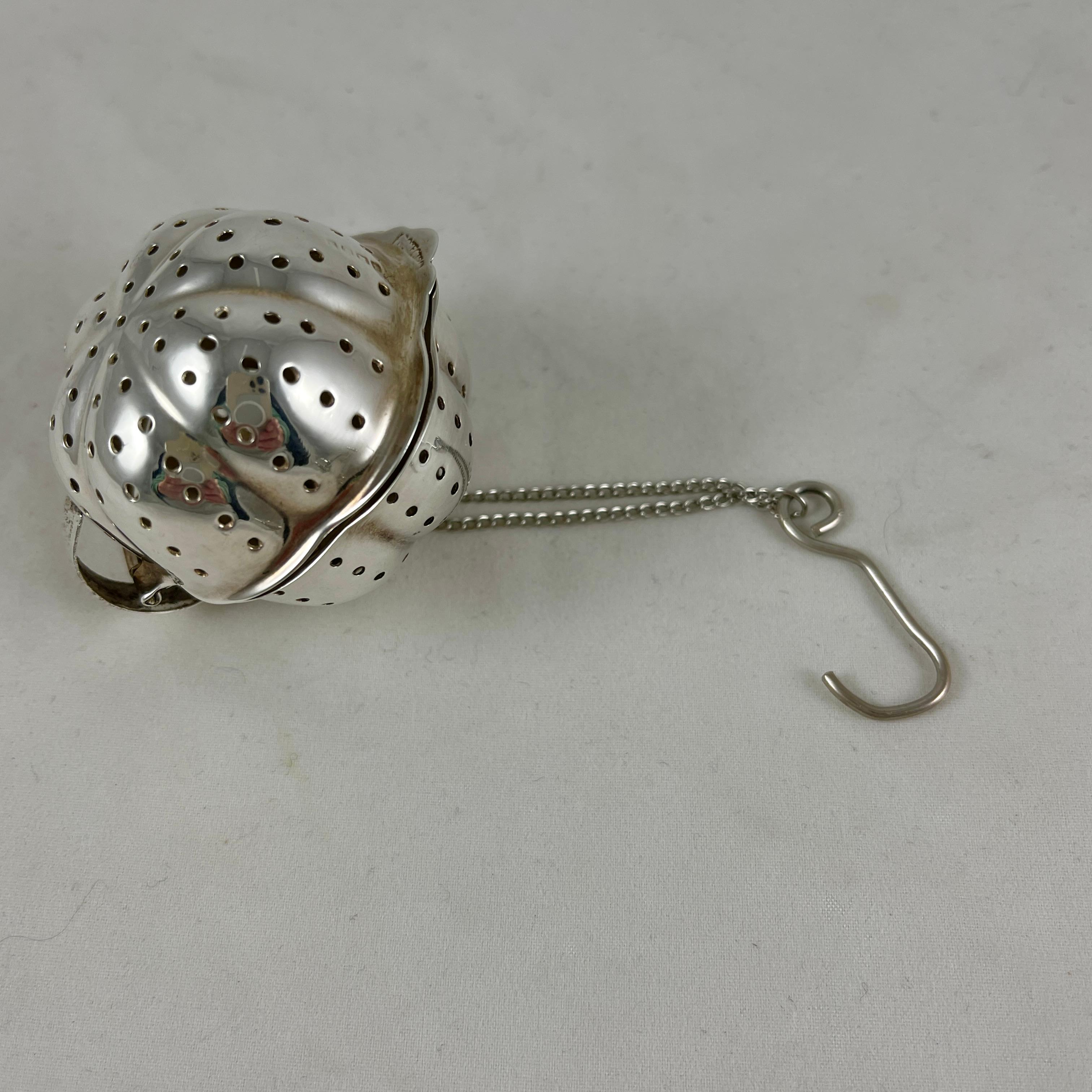 From England, a sterling silver tea ball infuser, showing makers marks, and stamped England, circa early 1900s.

A hinged opening for filling the ball with loose tea. Overall piercings allow the tea leaves to infuse directly into a cup of hot