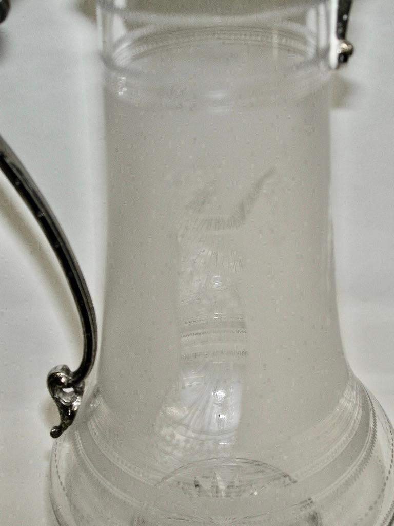 Antique etched glass claret jug with silver plated top, Circa 1870.
The etched glass depicts the three graces.
The silver plated mounts have cast features.