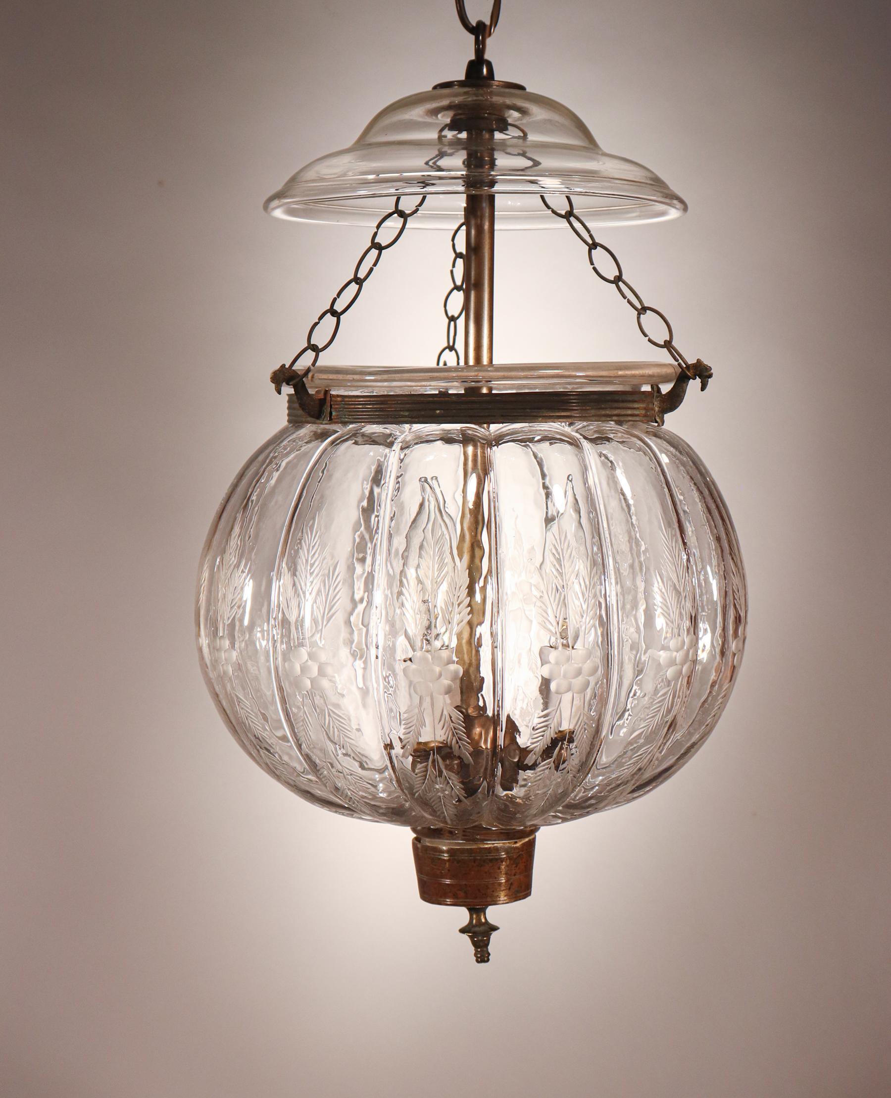 An antique Belgian melon or pumpkin-shaped bell jar lantern with an etched wheat motif, circa 1890. This authentic lantern features excellent quality hand blown glass, as well as its original smoke bell/lid, rolled brass band and finial/candle