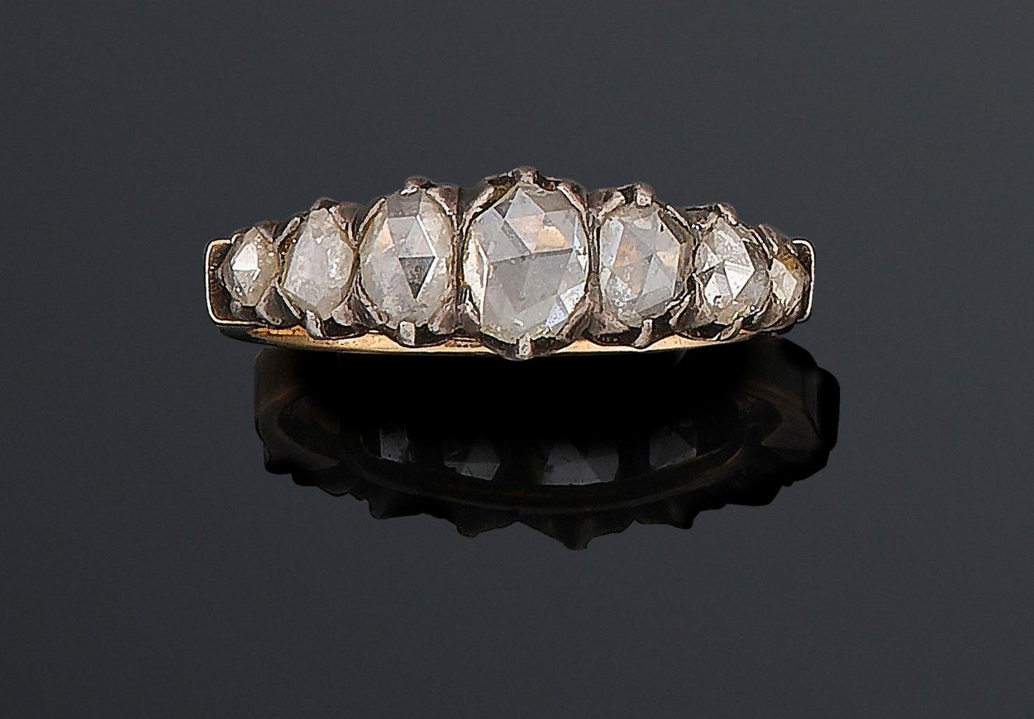 Half hoop ring in silver and gold adorned with a falling line of diamonds cut into crowned roses. Finger size: 8 1/2.

Width : 6mm. Gross weight: 3.7 g.

The five and seven-stone half hoop rings were one the most popular rings forms of the late 19th