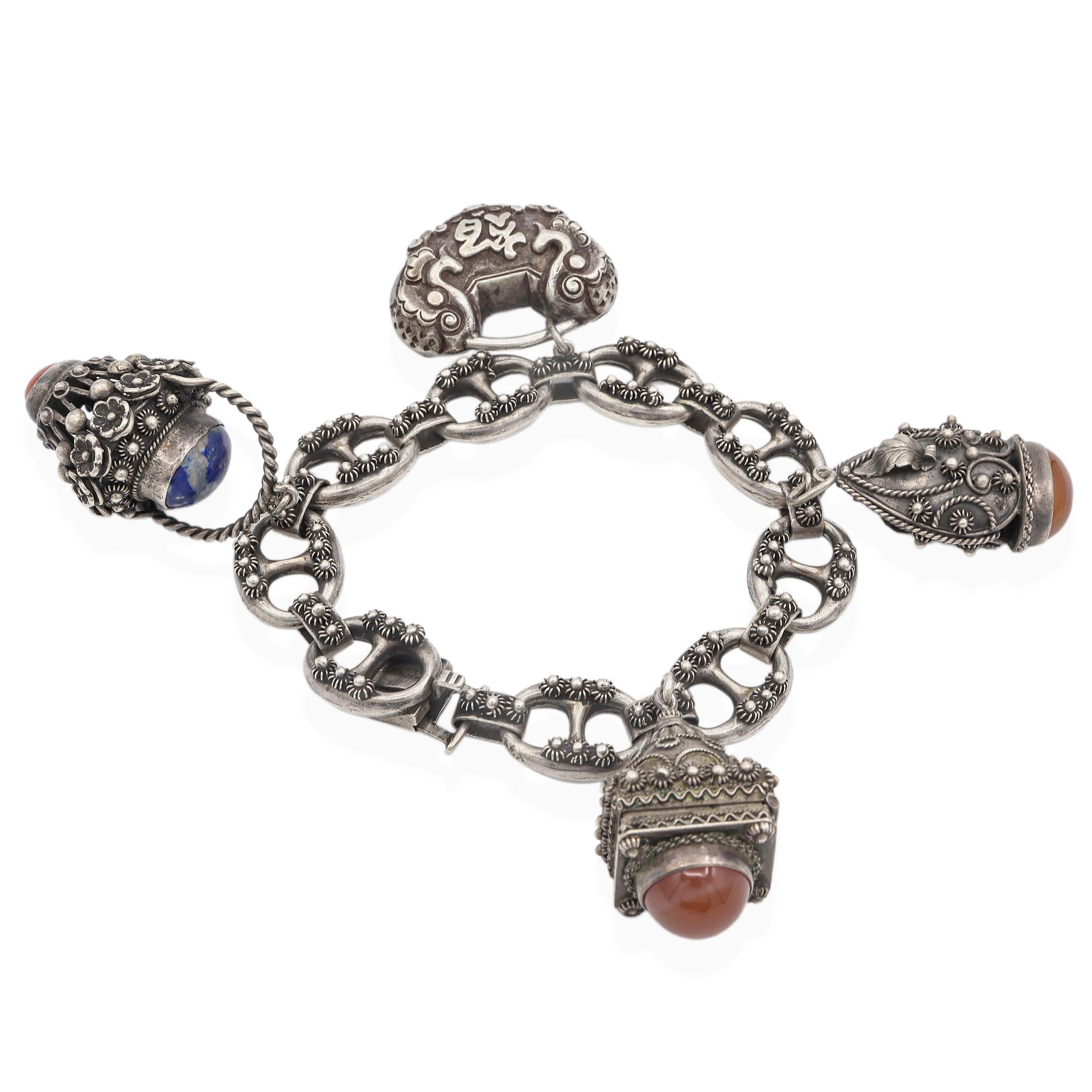 Questo squisito bracciale antico è realizzato in argento 800 e disegnato nello sfarzoso stile Etruscan Revival, popolare nel XIX e all'inizio del XX secolo. Il braccialetto è caratterizzato da maglie ornamentali impreziosite da una fine granulazione