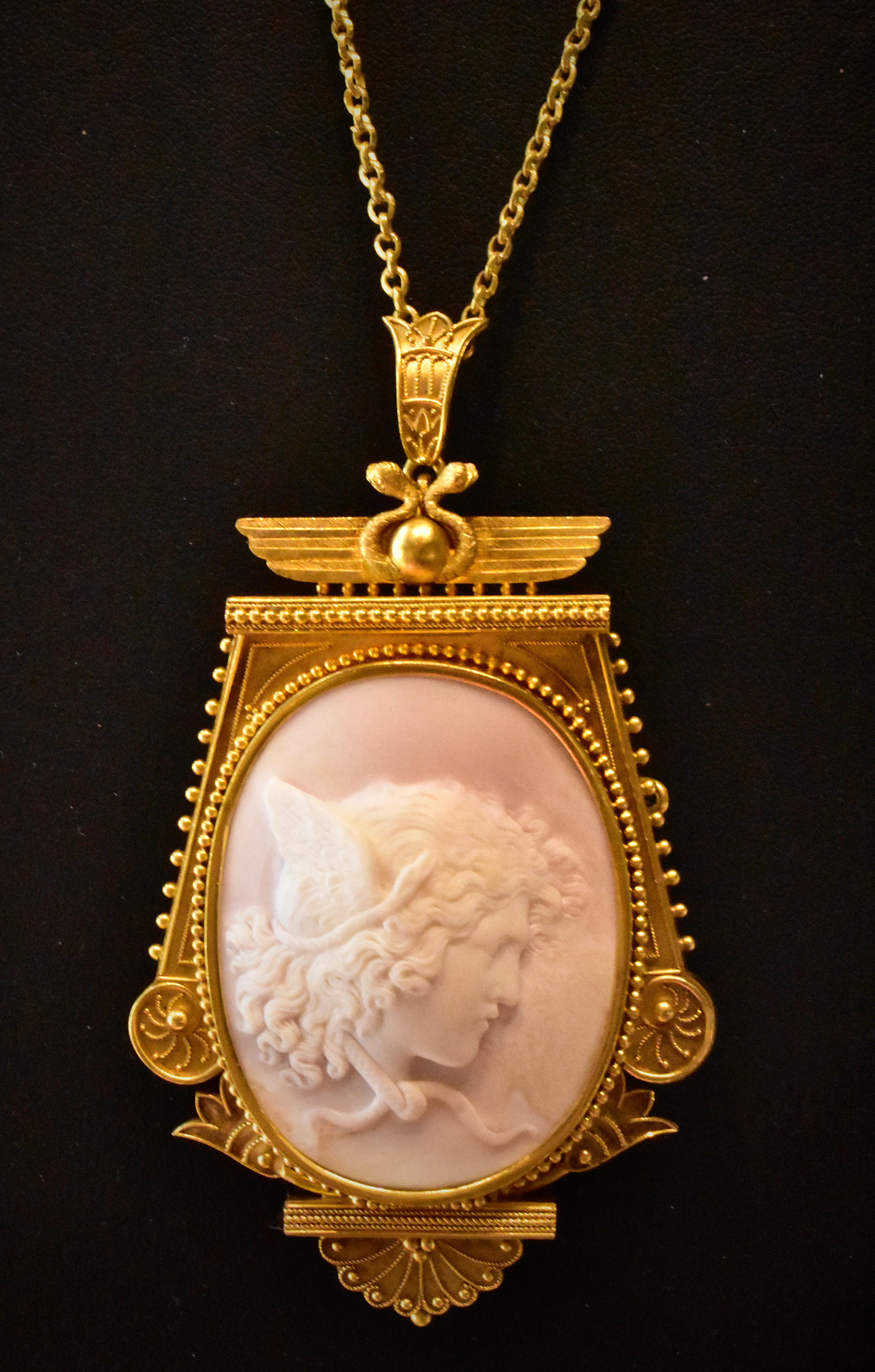 Large and Exquisite Etruscan Revival pale pink hand carved conch shell cameo of Medusa, American, 1875.

Set in 14K yellow gold with an acid finish or 