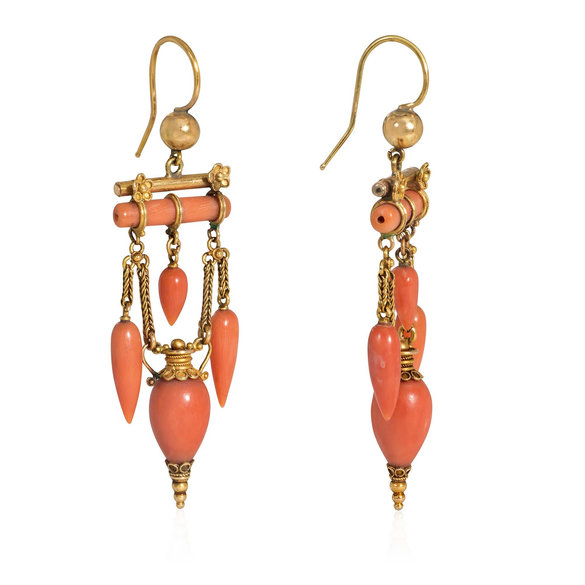 A pair of antique coral and gold Etruscan Revival earrings of girandole design, comprised of three drop-shaped coral pendants suspended from a coral baton and terminating in a coral urn, with gold bead surmounts and foxtail chain festoons, in