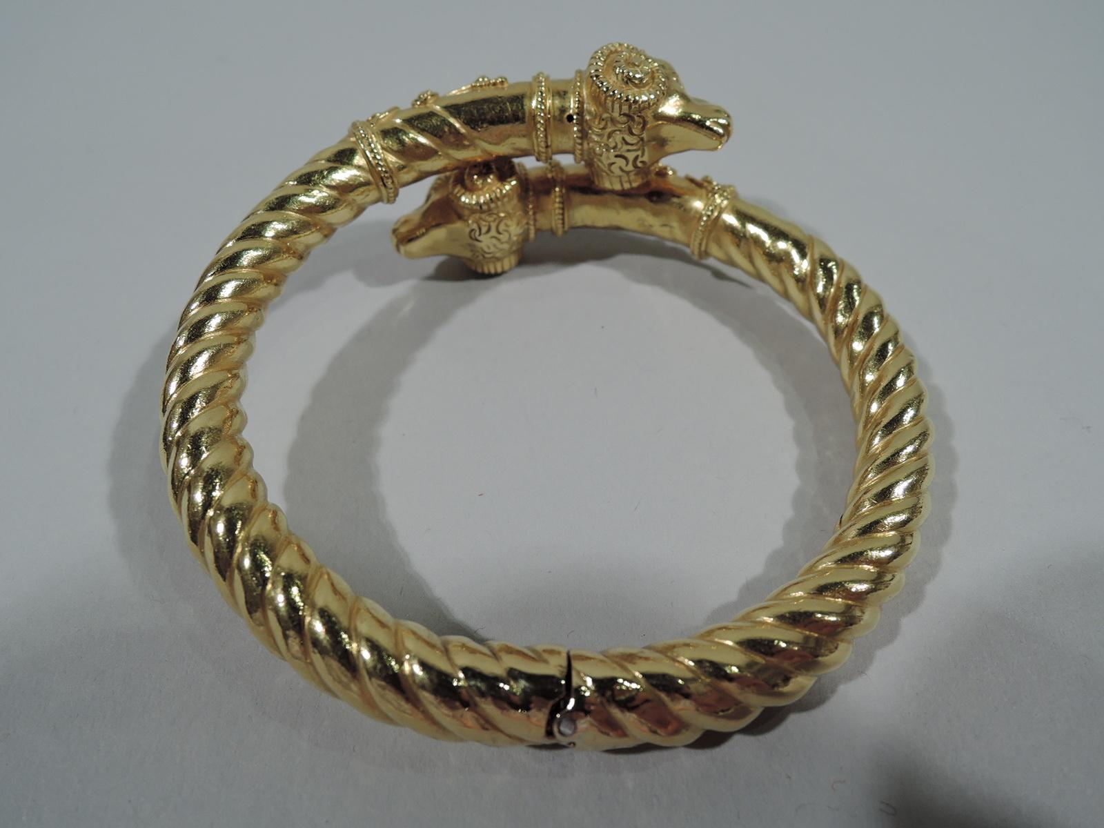 A beautifully crafted Etruscan-Revival 18K gold bangle bracelet with 2 ramâ€™s heads decorated with filigree bead work, floral filigree collars, and rope band. Italy, ca. 1890. Fits a medium wrist.

Circumference interior: 6 3/4 in. Weight: 31.8