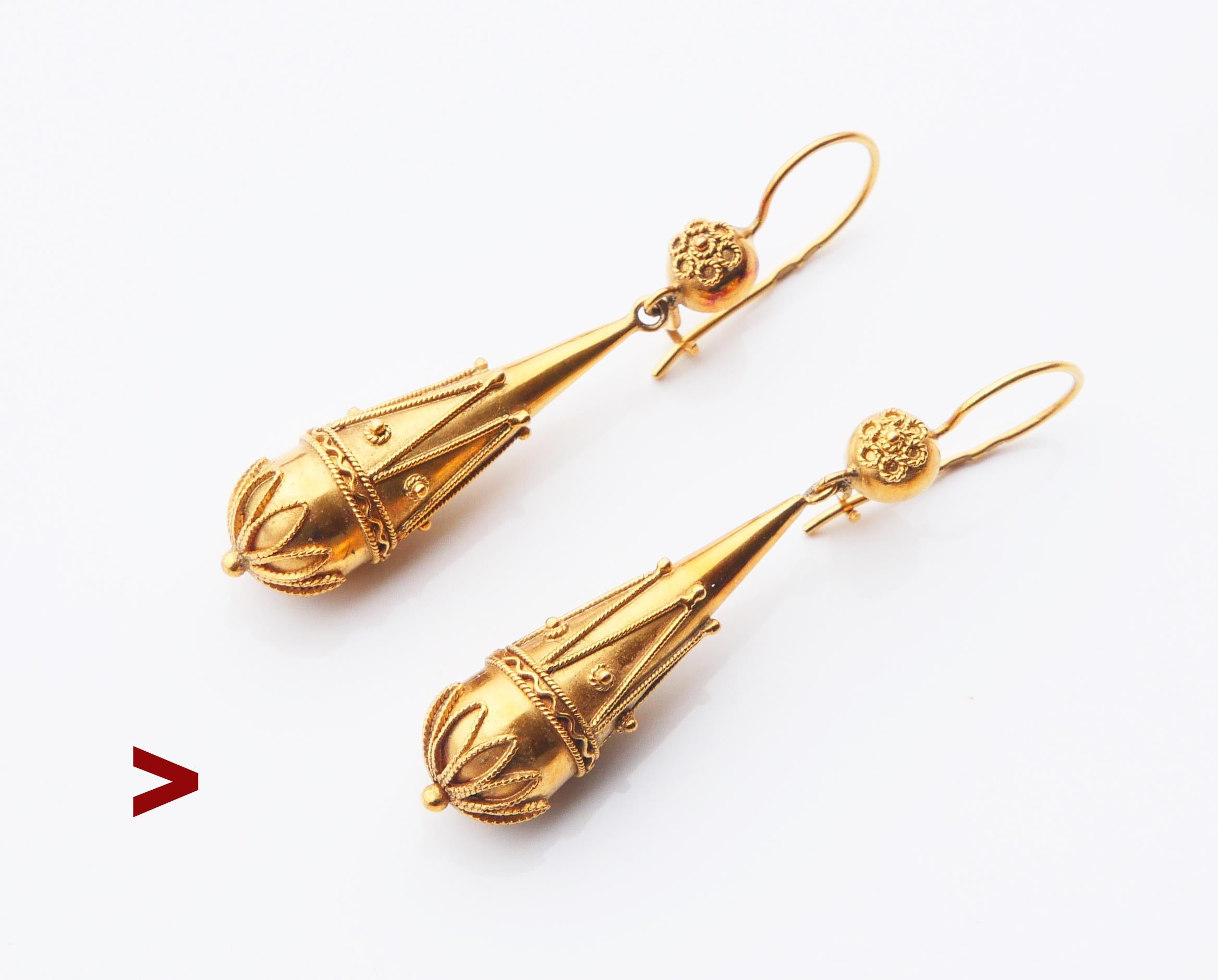 A pair of voluptuous drop shaped dangles,Etruscan styled,with filigree and granulation decorations affixed to metal base.

Both hallmarked 750, CCC, likely German, hand- made ca. 1900s- 1930s. 

Each earring is 52 mm long , Ø 9.6 mm at widest.