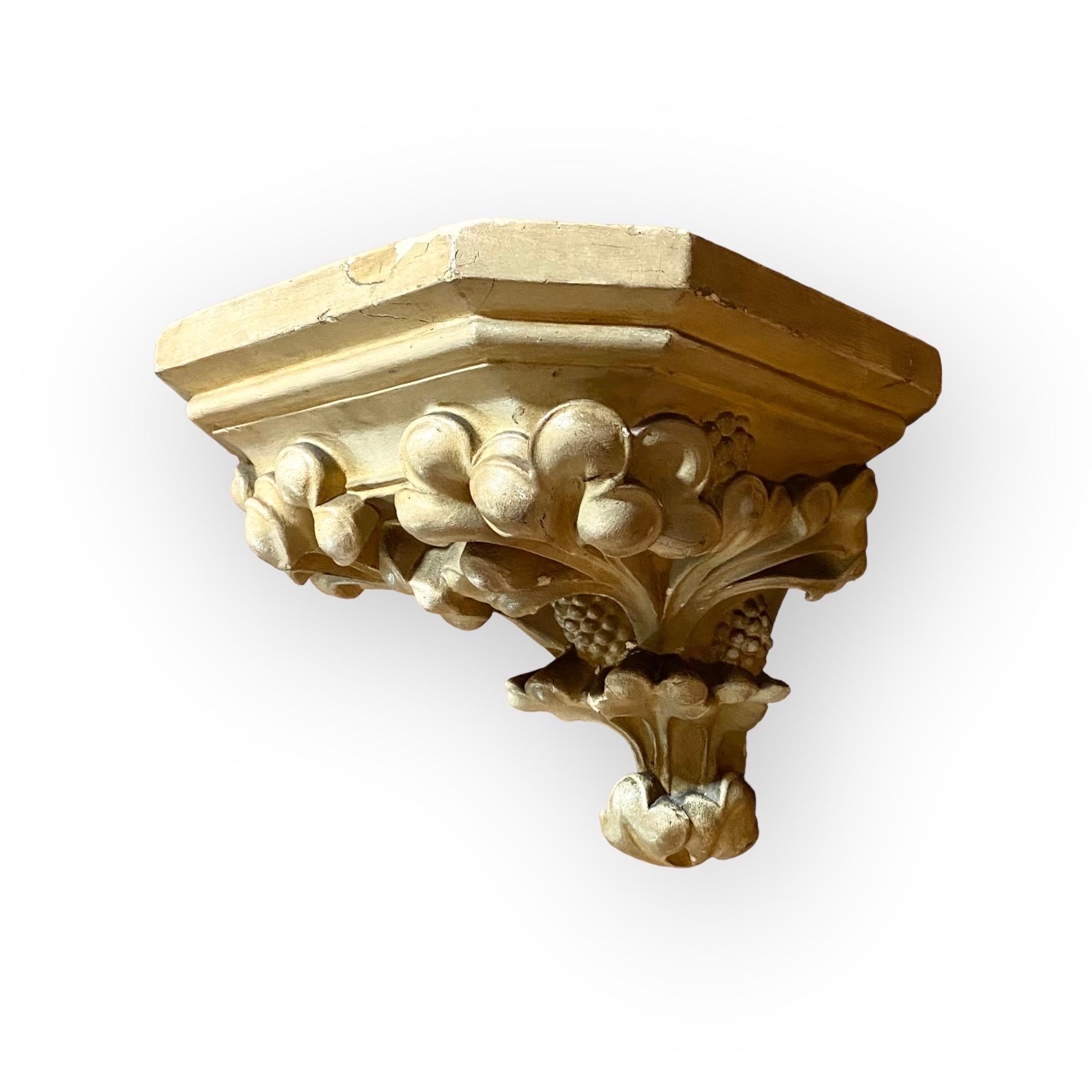 This extended octagonal plaster corbel/wall shelf, possibly Venetian, is in its original colors of painted grey/cream with gold burnished highlights and decorated with molded and stylized berries and leaves. Two back hooks will secure the bracket to