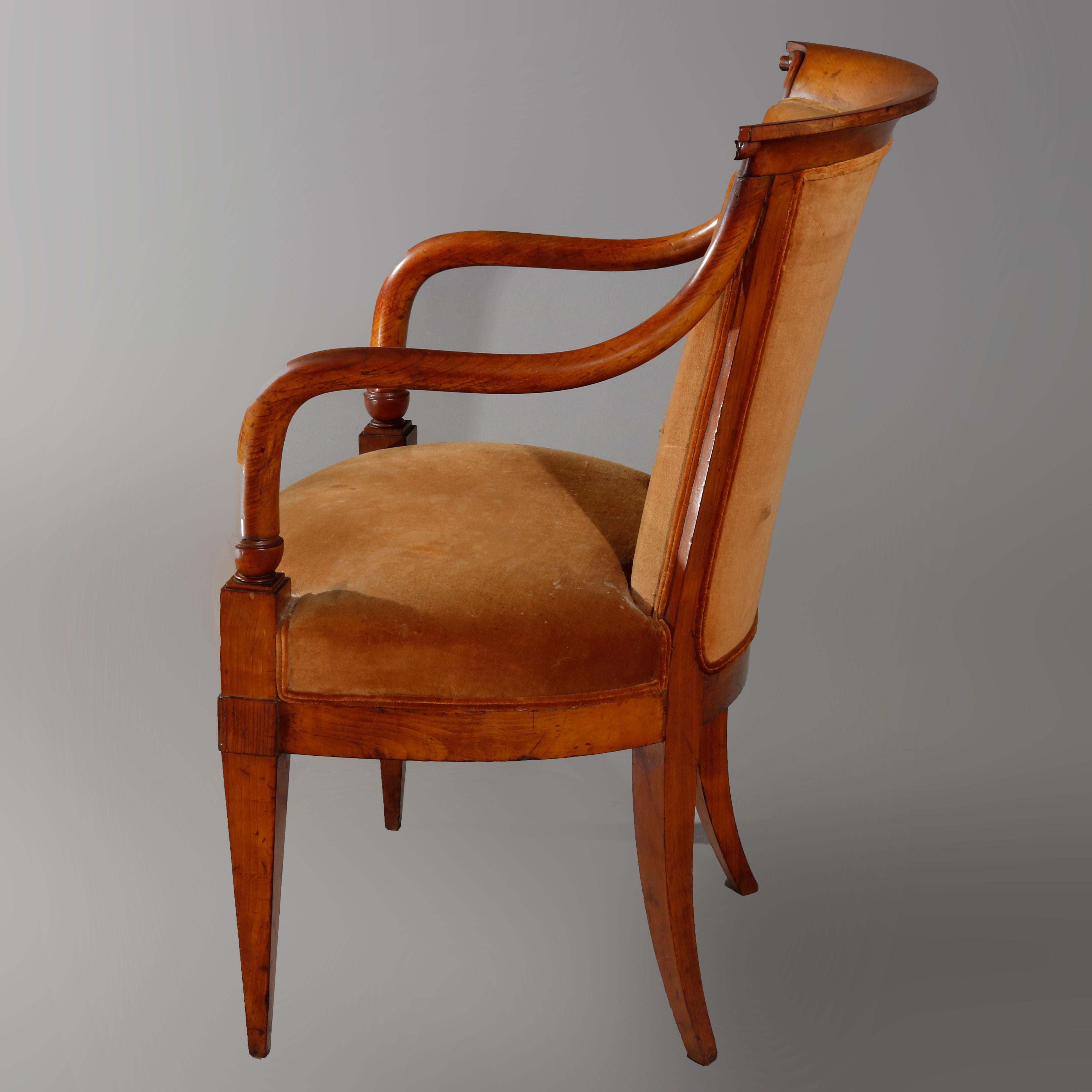 An antique European Biedermeier armchair offers walnut frame with scroll form crest surmounting upholstered back and seat, raised on square and tapered legs, circa 1820

Measures: 35.25