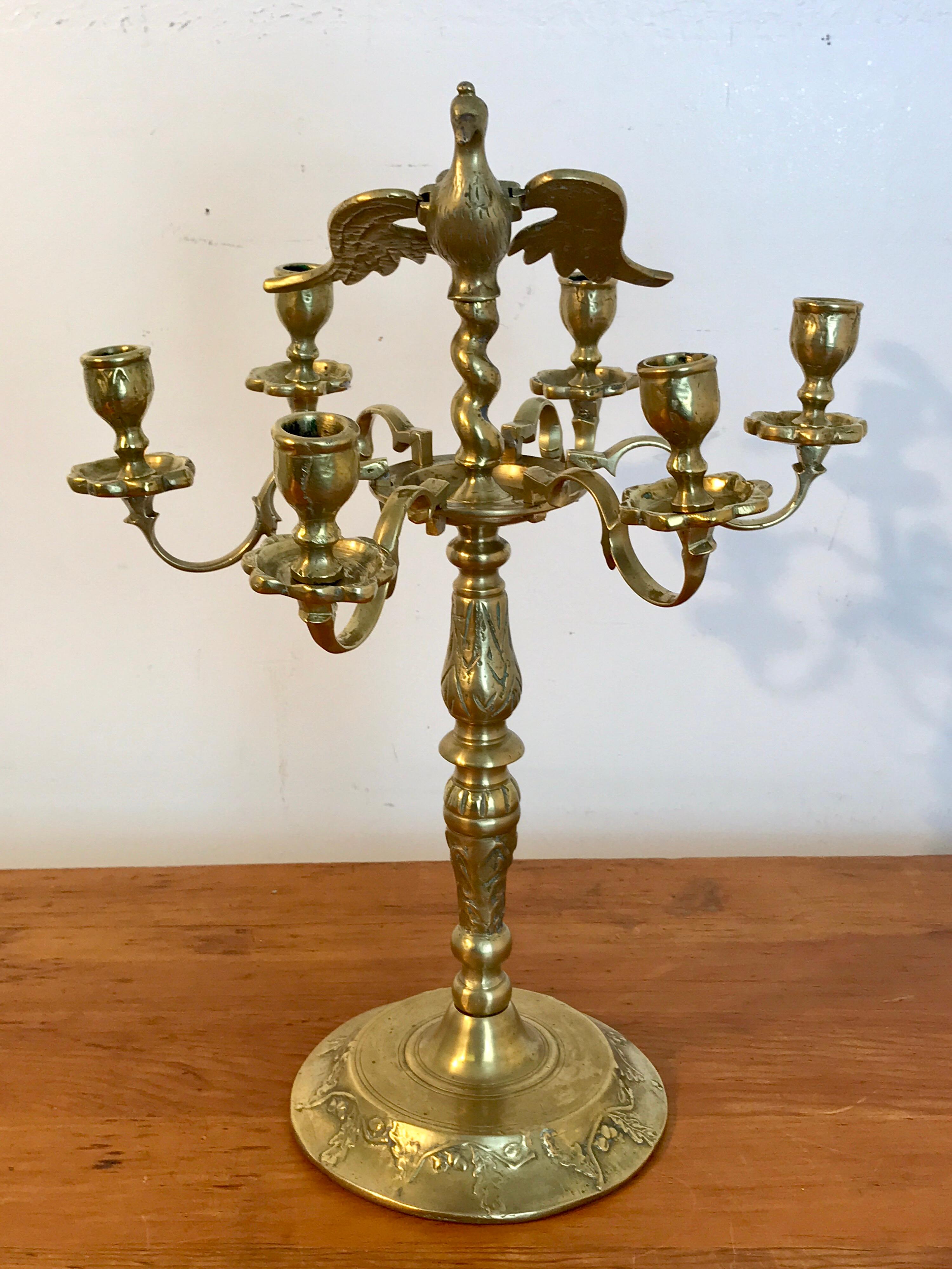 Antico candelabro figurato in ottone europeo, con uccello alato centrale e sei bracci a candela, sollevato su una base circolare con piedistallo di 7 pollici. Forse polacco o russo. Le ali degli uccelli si staccano, alcuni bracci delle candele sono