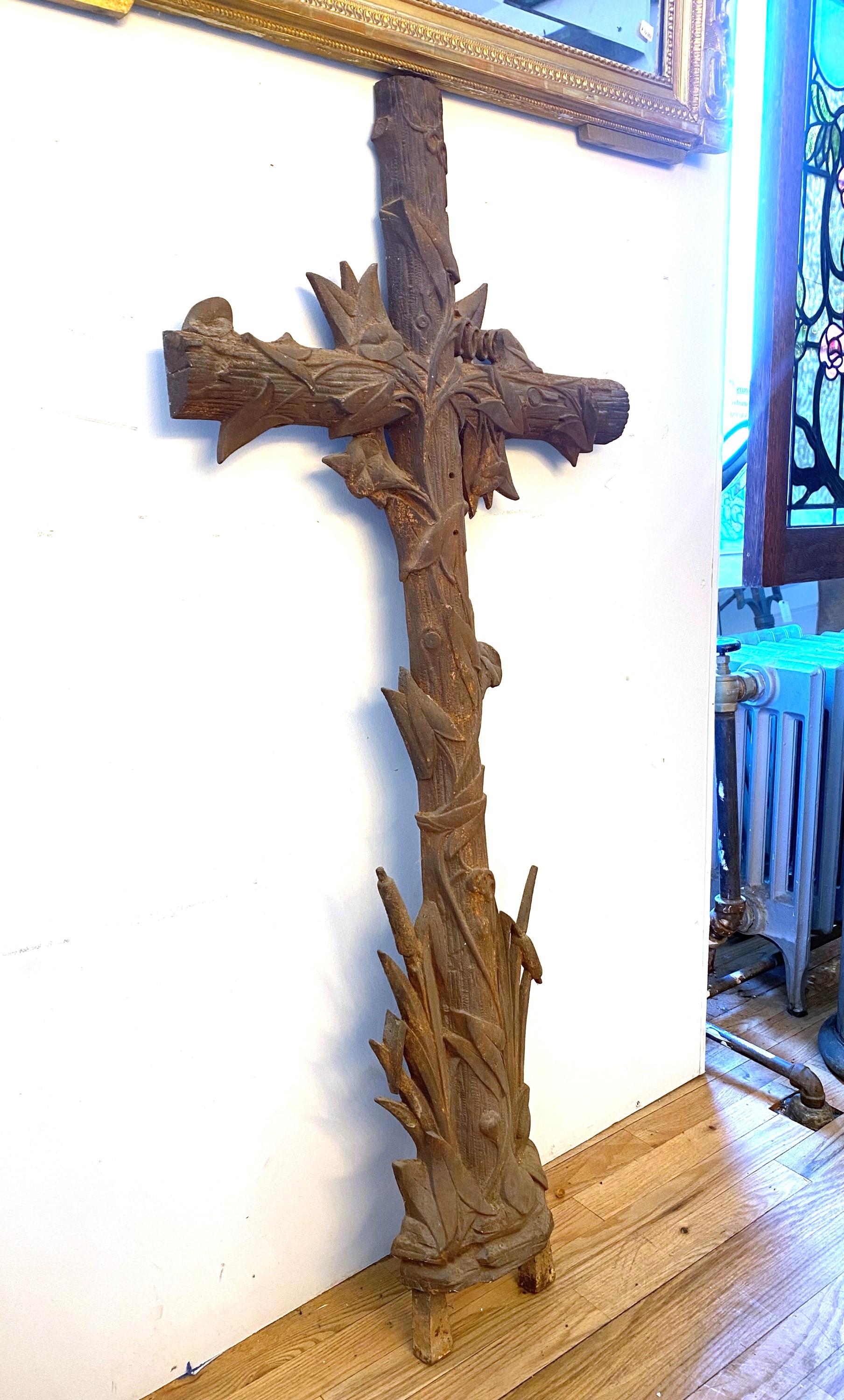 Antique European wall mounted cast iron cross featuring a wood design with floral flowers and leaves sprouting up and around the cross. Mounting holes for mounting to a wall. Please note, this item is located in one of our NYC locations.