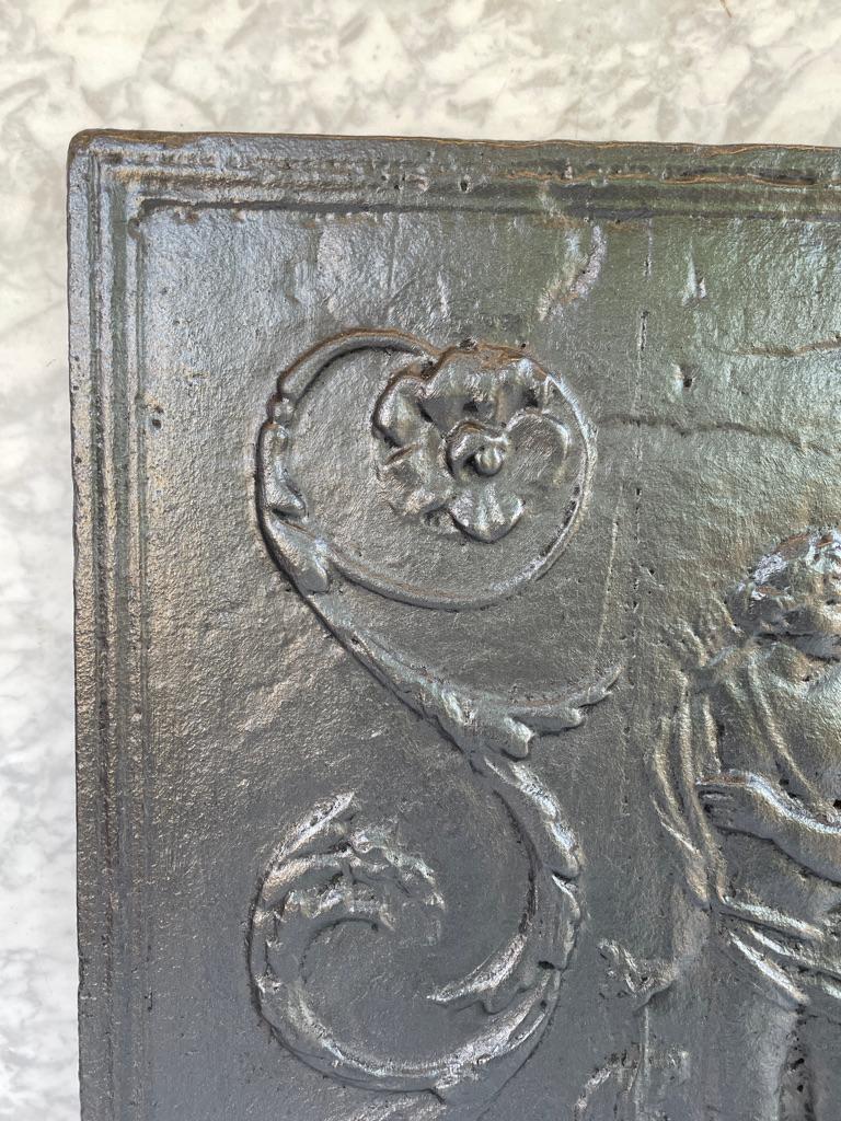 Antike gusseiserne Kaminrückwand mit klassischer Szene. 
  
