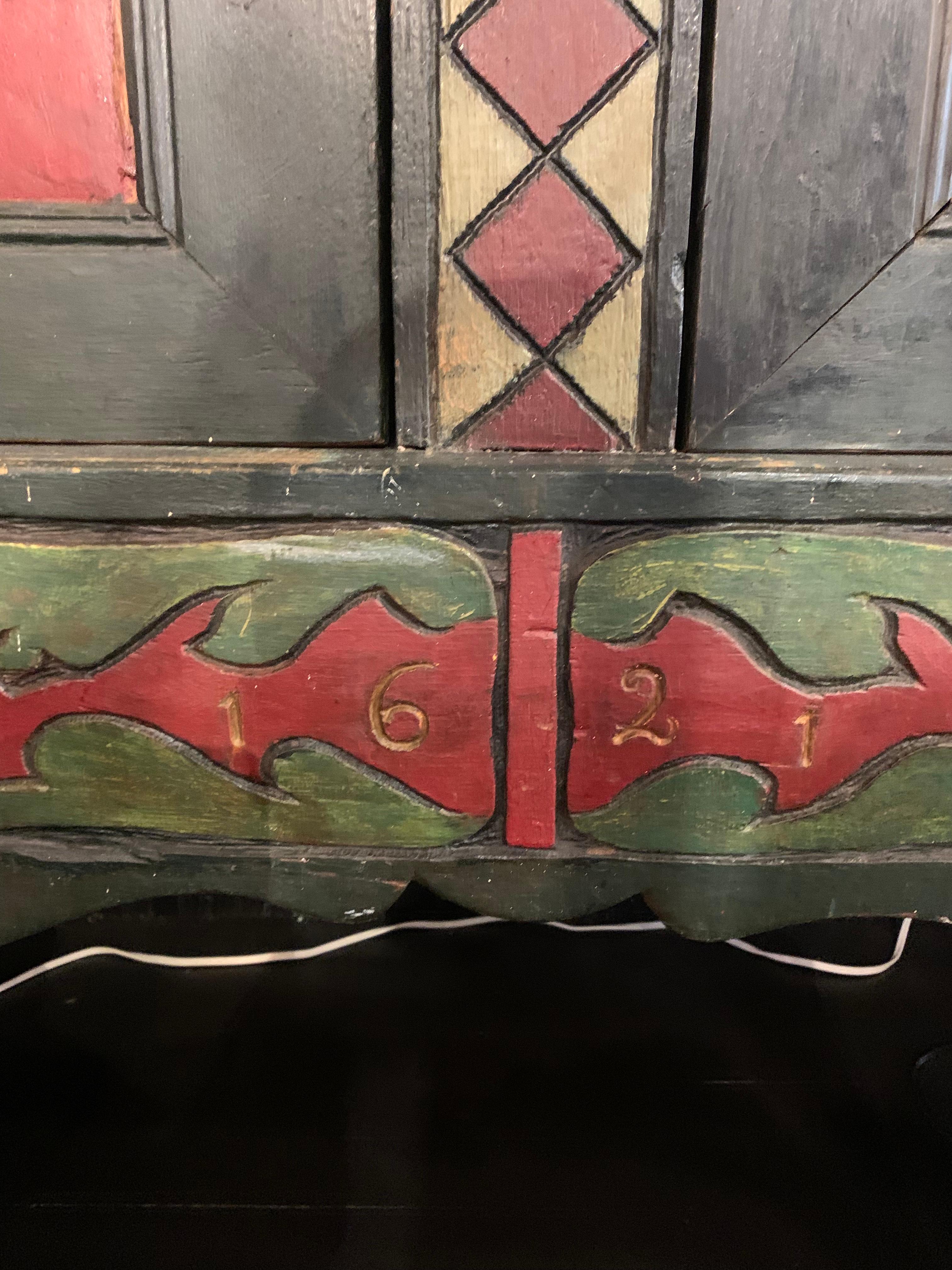 Exceptional brightly painted colonial folk cabinet in excellent condition, with some minor repairs. The date of “1621” is carved in the front panel with a carved man and woman figure head in each corner. Possibly a wedding chest. Original hardware.
