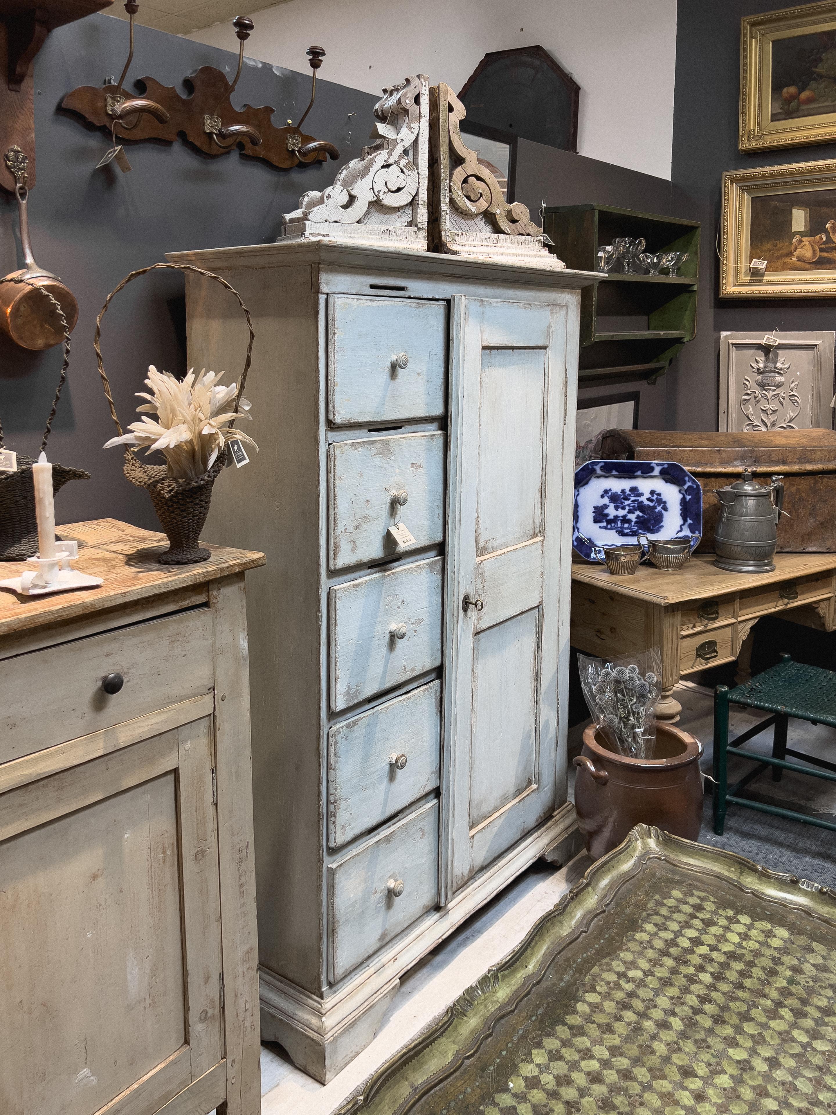 Circa 1870s European kitchen cupboard with a restored painted finish. A single key is able to lock all five drawers and keep the cupboard door closed. There is a slot above each drawer perhaps to insert paperwork while it's locked.

Piece is