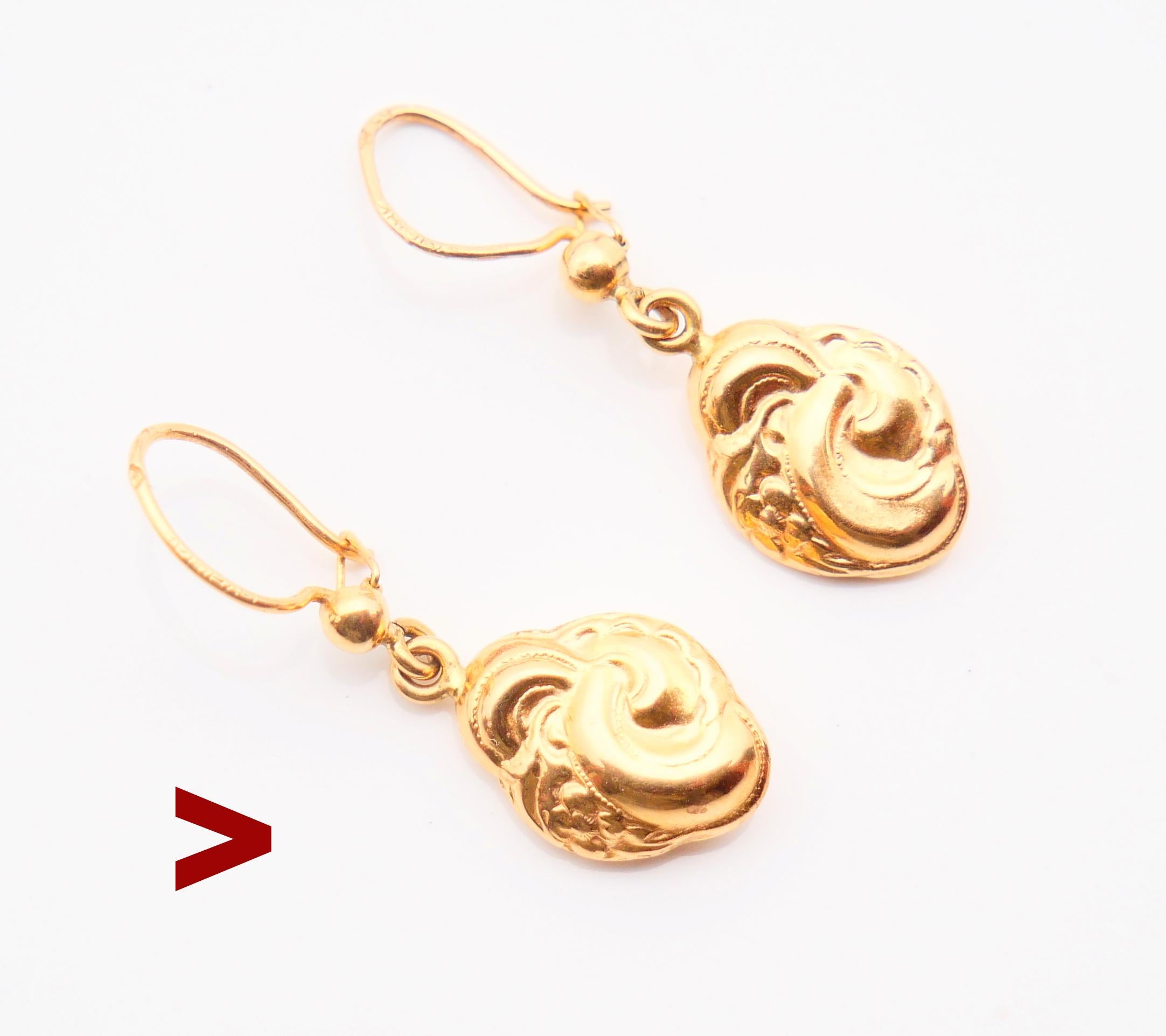 A pair of hollow cast pendants dangles in solid 18K Yellow Gold with cast identical voluptuous floral ornaments on both sides.

Hallmarked 18K , Swedish maker's hallmarks. Hallmarks are not clear to read. Made ca.1920-1940s.

Each earring is about